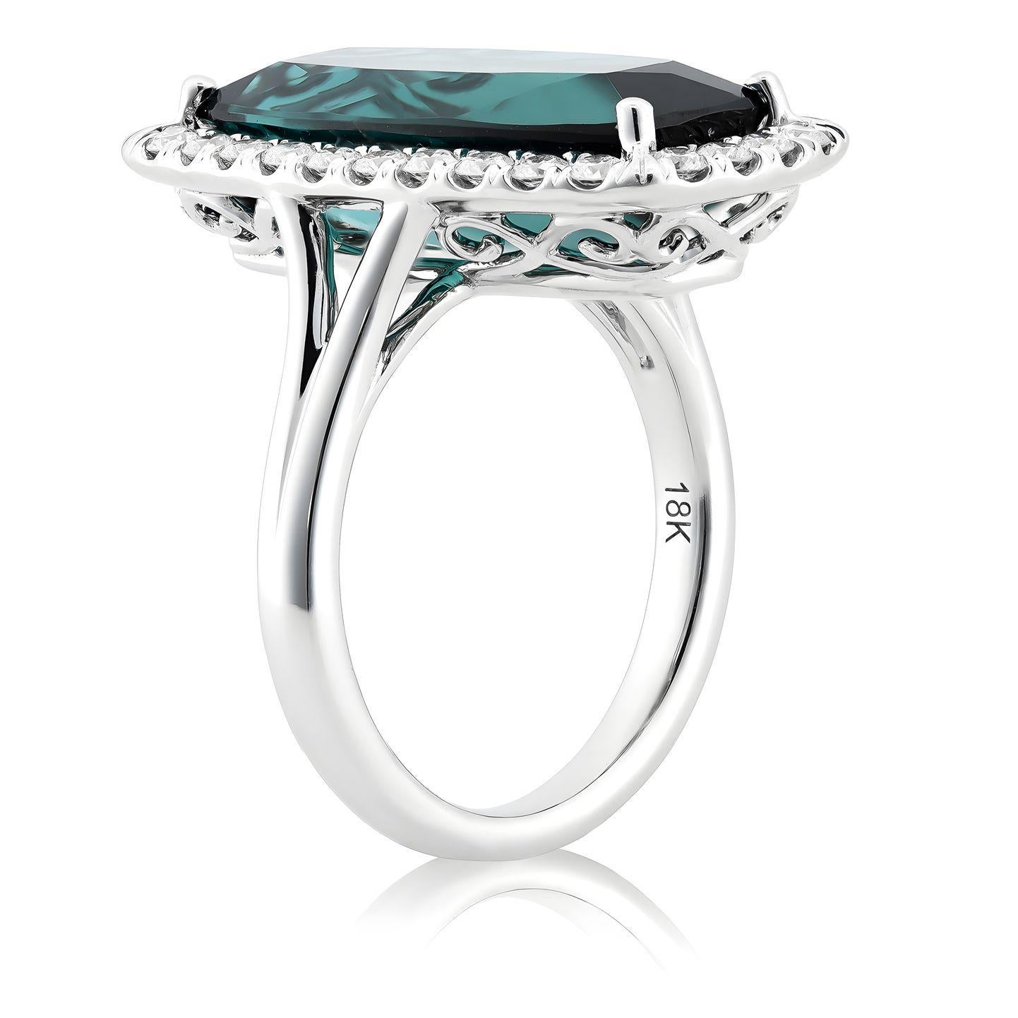 Discover the captivating elegance of this 18K white gold ring, featuring a natural blue indicolite tourmaline as its centerpiece, accented by brilliant diamonds. The cushion-cut indicolite, with its vibrant blue hue and exceptional clarity, is