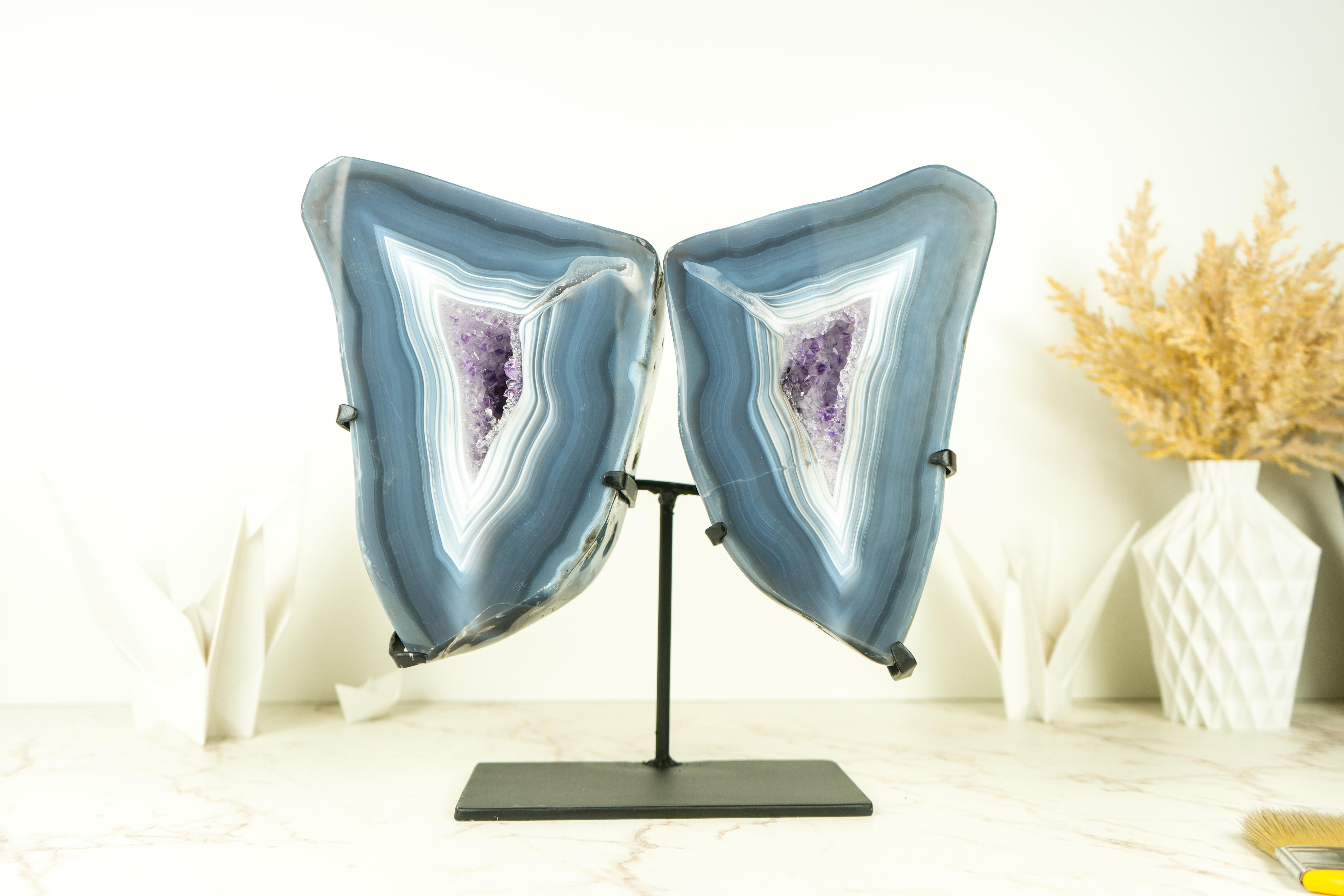 A fascinating agate geode that was cut open to show the world its internal beauty, this Agate Geode Wings combines world-class blue lace agate, purple amethyst druzy, and careful craftsmanship to become this spectacular natural artwork. Exceptional
