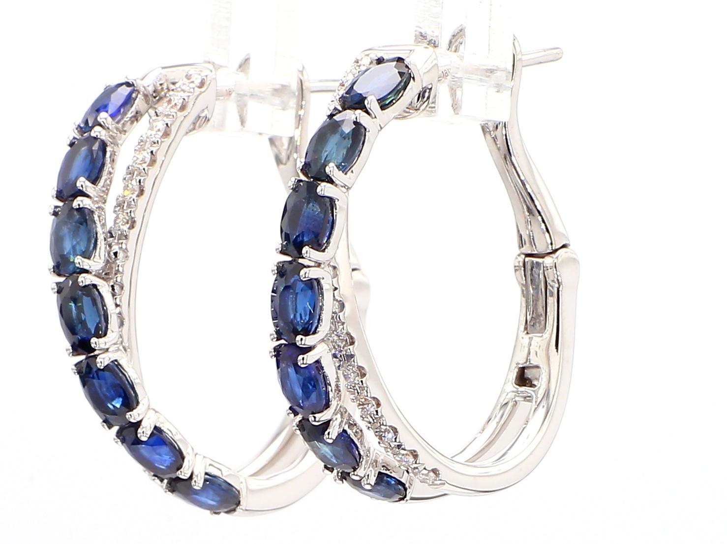 Les boucles d'oreilles classiques en saphir de Raregemworld. Monté dans une belle monture en or blanc 18 carats avec des saphirs bleus naturels de taille ovale complétés par une mêlée de diamants blancs ronds naturels. Ces boucles d'oreilles sont