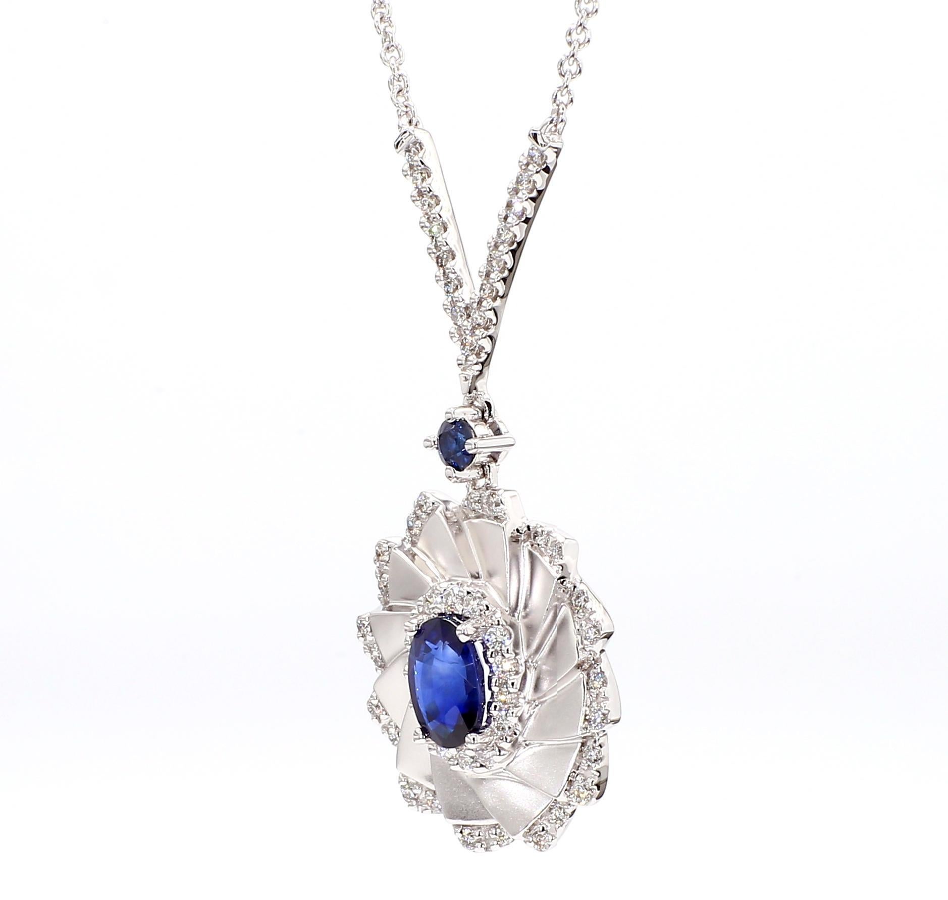 Le collier de saphirs intrigant de Raregemworld. Monté dans une belle monture en or blanc 18 carats avec un saphir bleu naturel de taille ovale. Le saphir est entouré d'un saphir bleu de taille ronde naturelle et d'une mêlée de diamants blancs de