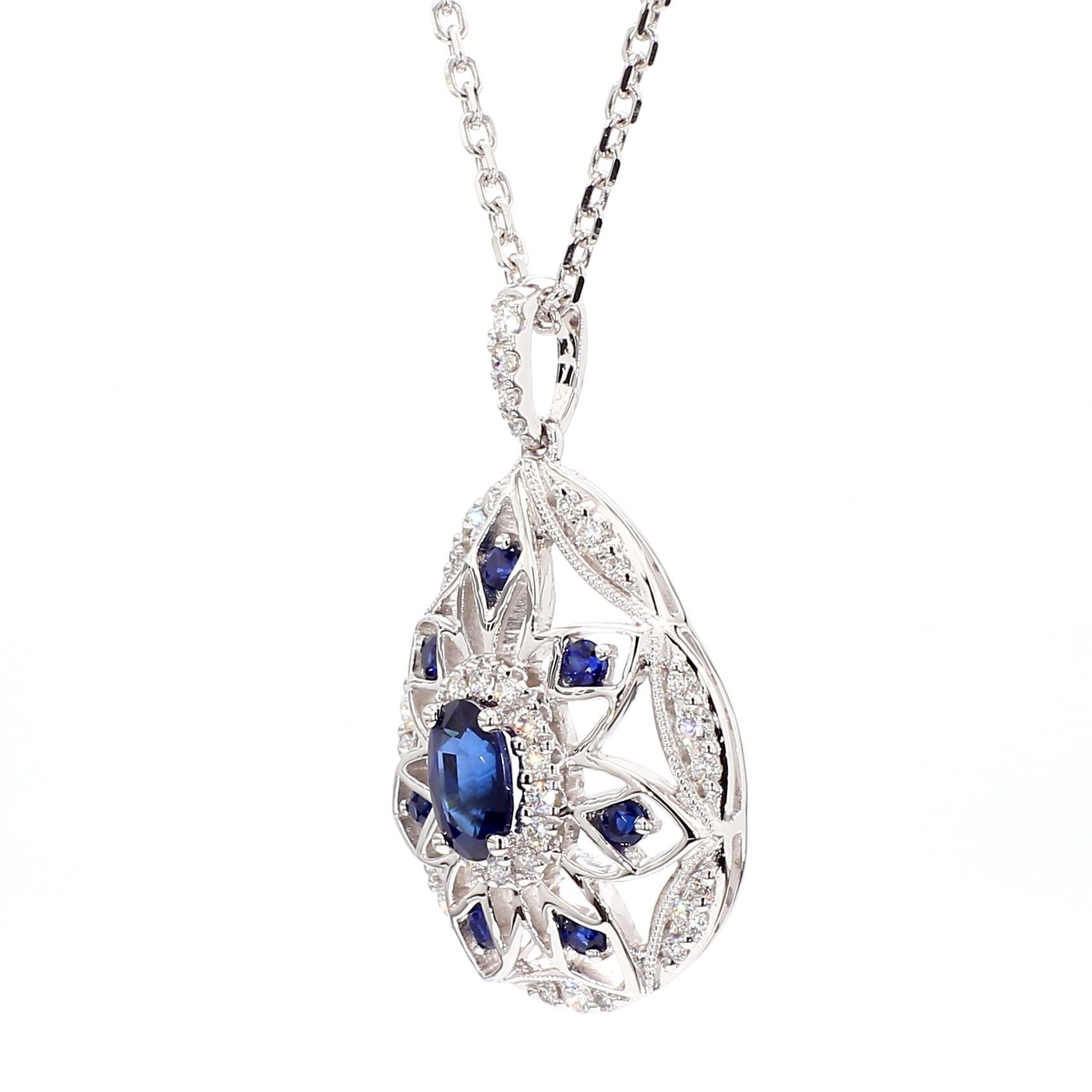 Le magnifique pendentif en saphir de Raregemworld. Monté dans une belle monture en or blanc 14 carats avec un saphir bleu naturel de taille ovale. Le saphir est entouré de saphirs bleus naturels de taille ronde et d'une mêlée de diamants blancs
