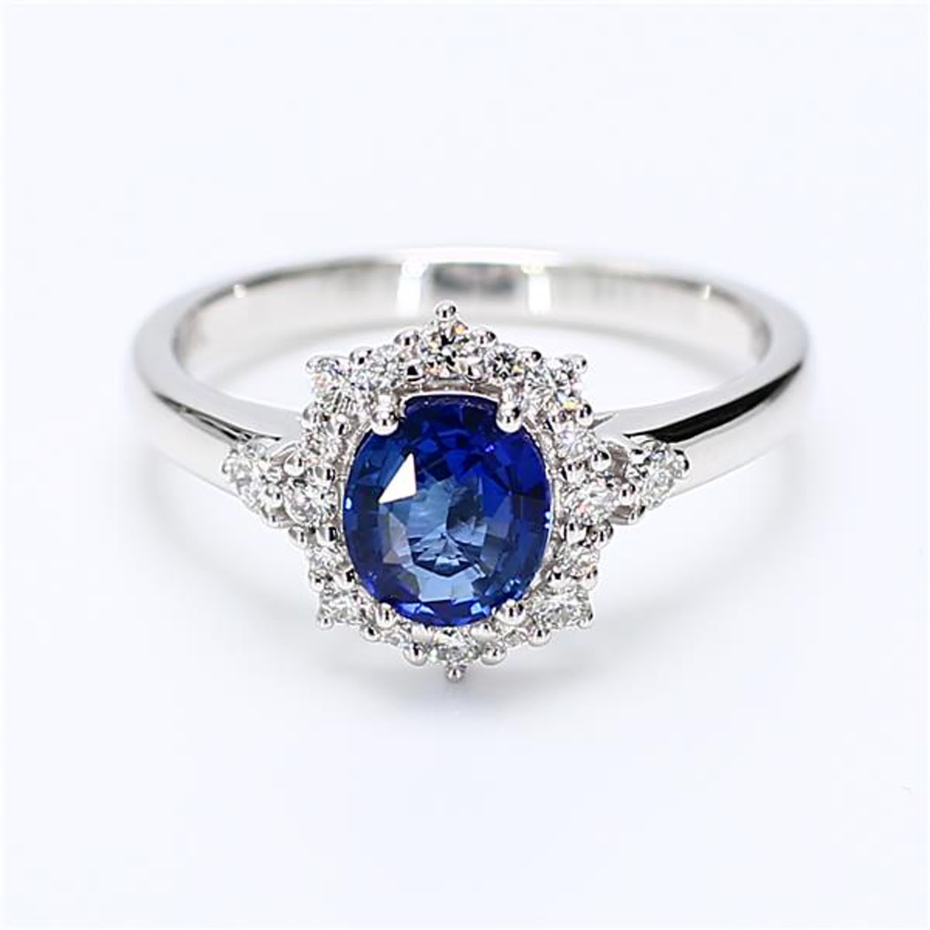 RareGemWorld's classic sapphire ring. Mounted in a beautiful 18K White Gold setting with a natural oval cut blue sapphire. The sapphire is surrounded by natural round white diamond melee. This ring is guaranteed to impress and enhance your personal