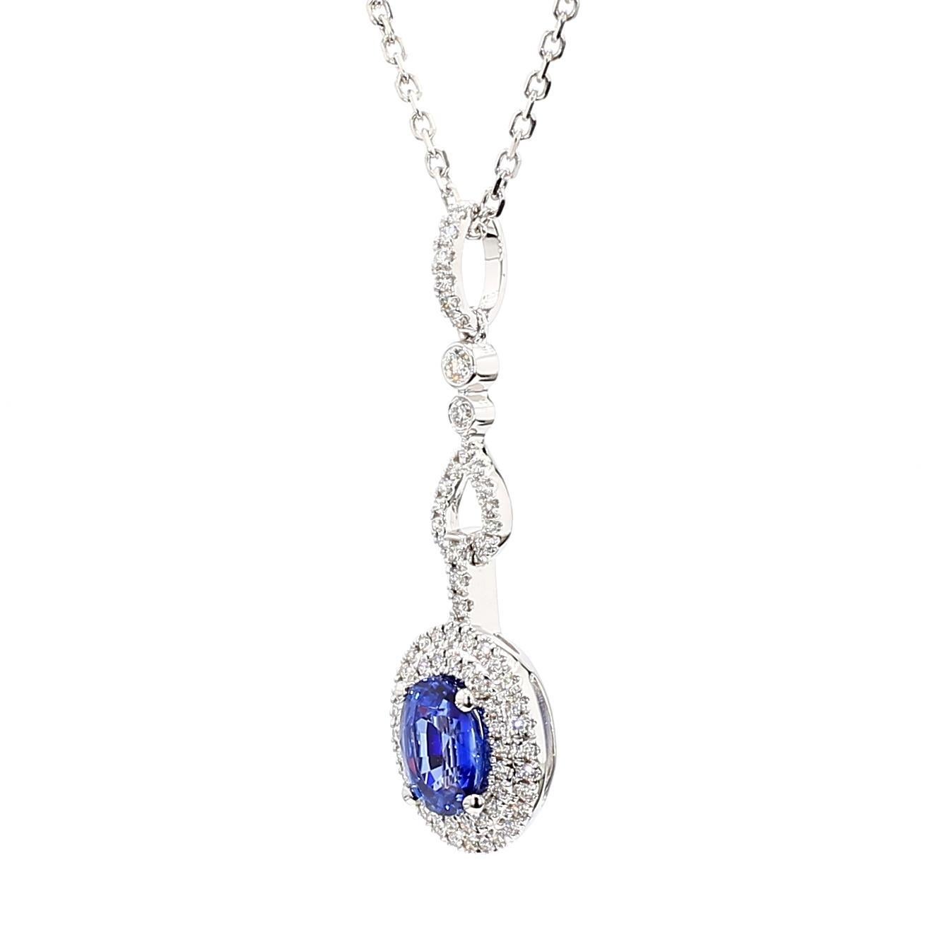 Precioso colgante de zafiro de RareGemWorld. Montada en un precioso engaste de oro blanco de 18 quilates con un zafiro azul natural de talla oval. El zafiro está rodeado de melee de diamantes blancos redondos naturales. Este colgante impresionará y
