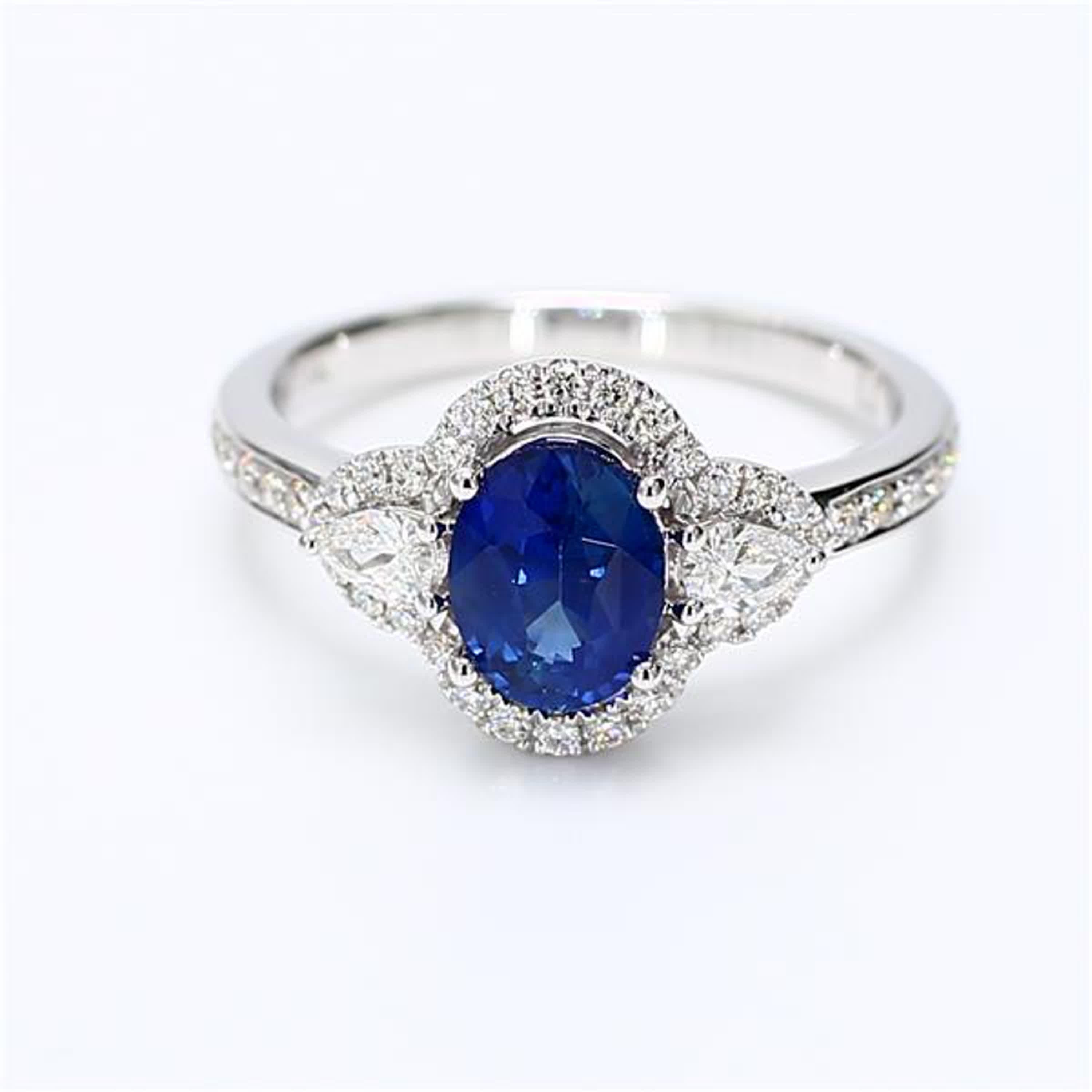 RareGemWorld's classic sapphire ring. Mounted in a beautiful 18K White Gold setting with a natural oval cut blue sapphire. The sapphire is surrounded by natural pear cut white diamonds and natural round white diamond melee. This ring is guaranteed