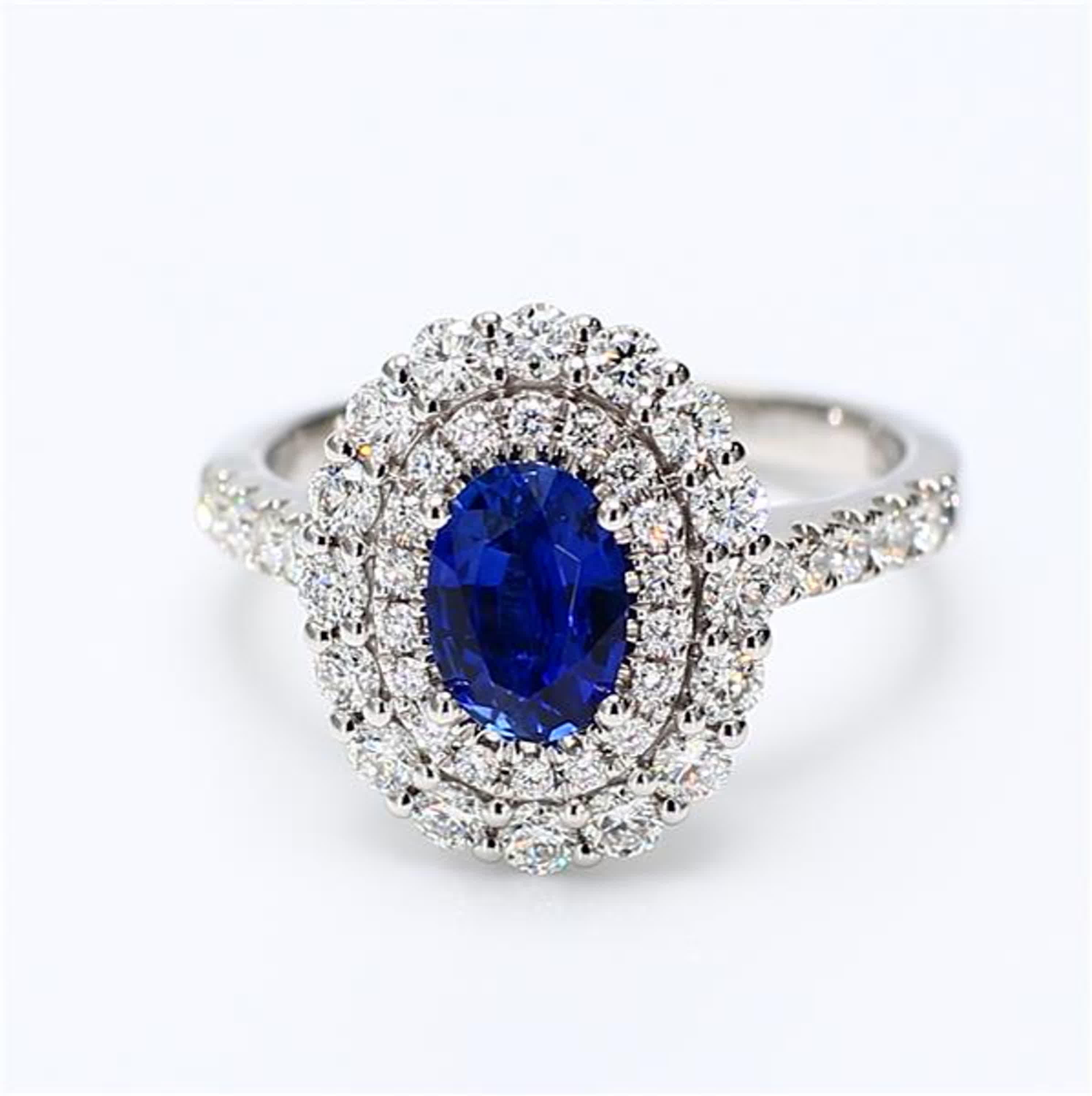 RareGemWorld's classic sapphire ring. Mounted in a beautiful 18K White Gold setting with a natural oval cut blue sapphire. The sapphire is surrounded by natural round white diamond melee. This ring is guaranteed to impress and enhance your personal