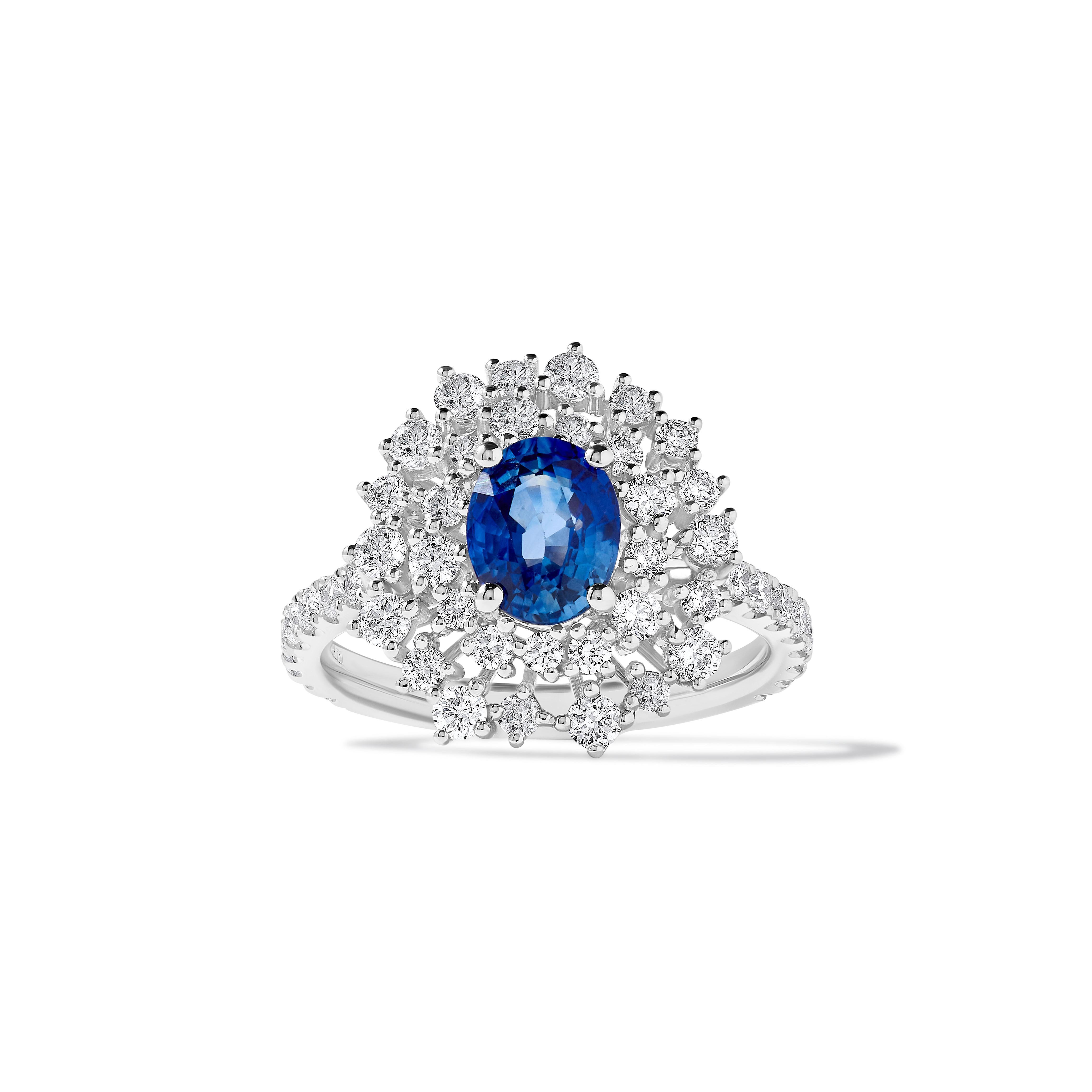 RareGemWorld's beautiful sapphire ring. Mounted in a beautiful 18K White Gold setting with a natural oval cut blue sapphire. The sapphire is surrounded by natural round white diamond melee. This ring is guaranteed to impress and enhance your