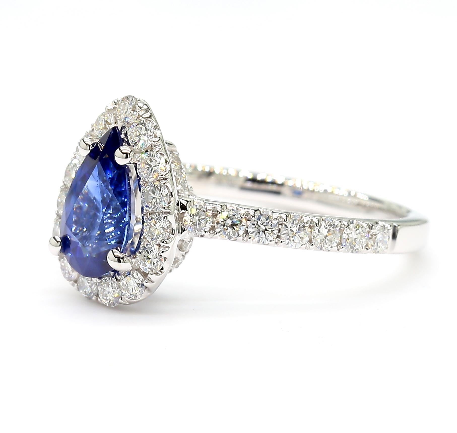 RareGemWorld's classic sapphire ring. Mounted in a beautiful 18K White Gold setting with a natural pear cut blue sapphire. The sapphire is surrounded by natural round white diamond melee. This ring is guaranteed to impress and enhance your personal