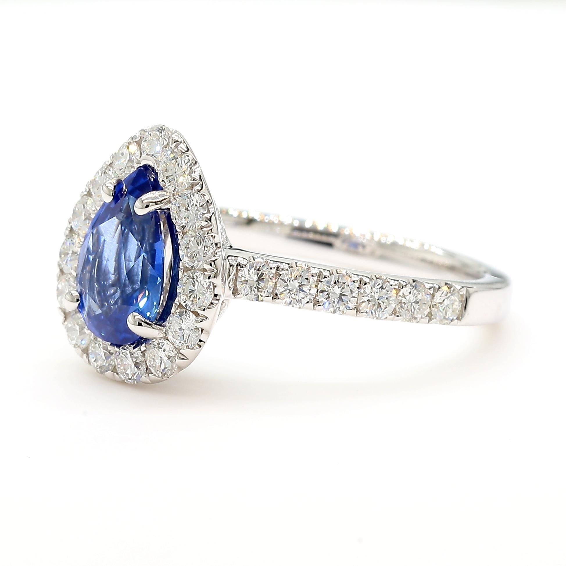 RareGemWorld's beautiful sapphire ring. Mounted in a beautiful 18K White Gold setting with a natural pear cut blue sapphire. The sapphire is surrounded by natural round white diamond melee. This ring is guaranteed to impress and enhance your