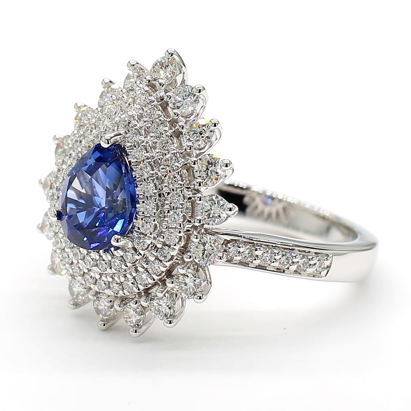 RareGemWorld's beautiful sapphire ring. Mounted in a beautiful 18K White Gold setting with a natural pear cut blue sapphire. The sapphire is surrounded by natural round white diamond melee. This ring is guaranteed to impress and enhance your