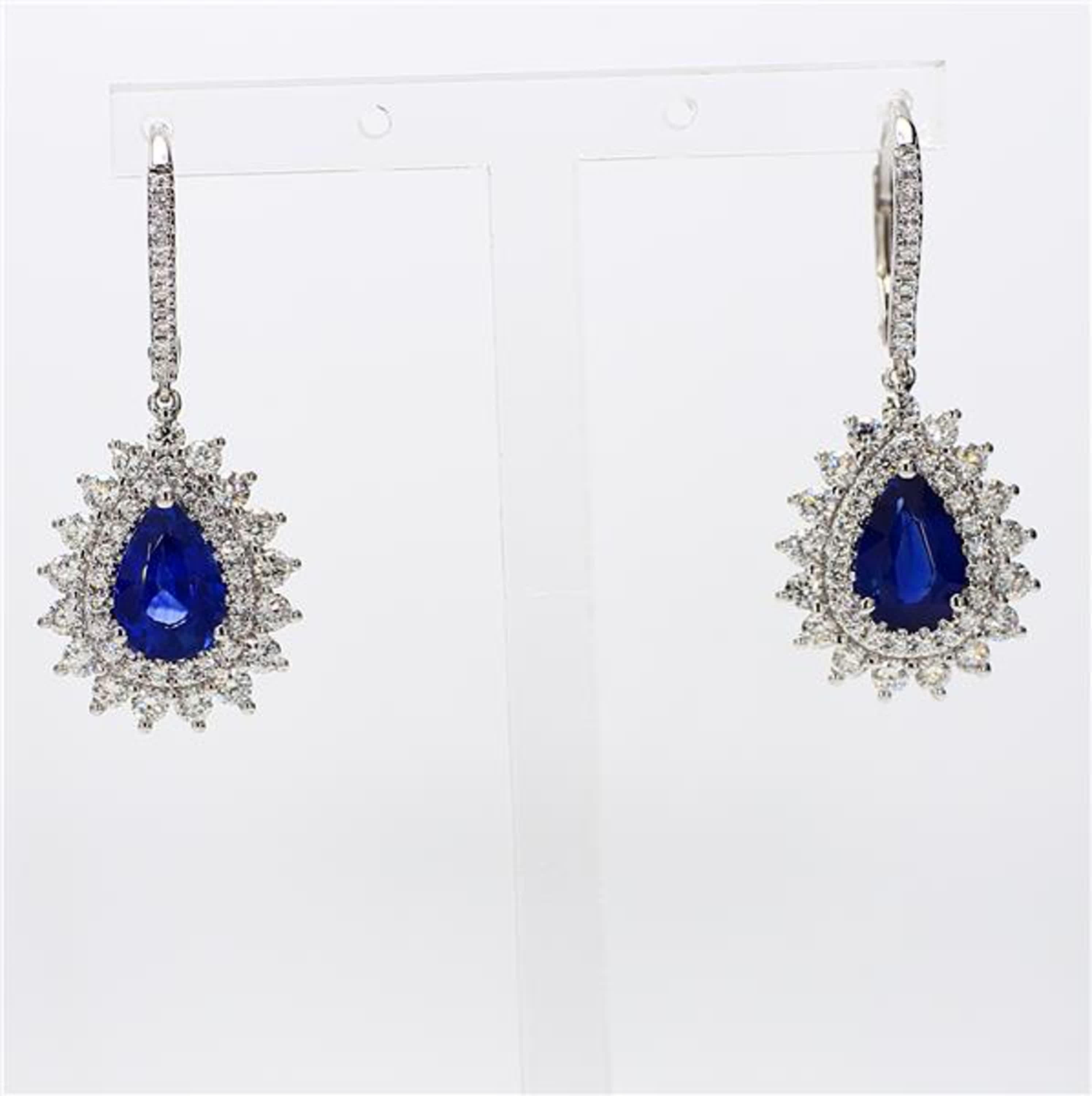 RareGemWorld's classic sapphire earrings. Mounted in a beautiful 18K White Gold setting with natural pear cut blue sapphires. The sapphires are surrounded by natural round white diamond melee as well as diamonds throughout the earring. These