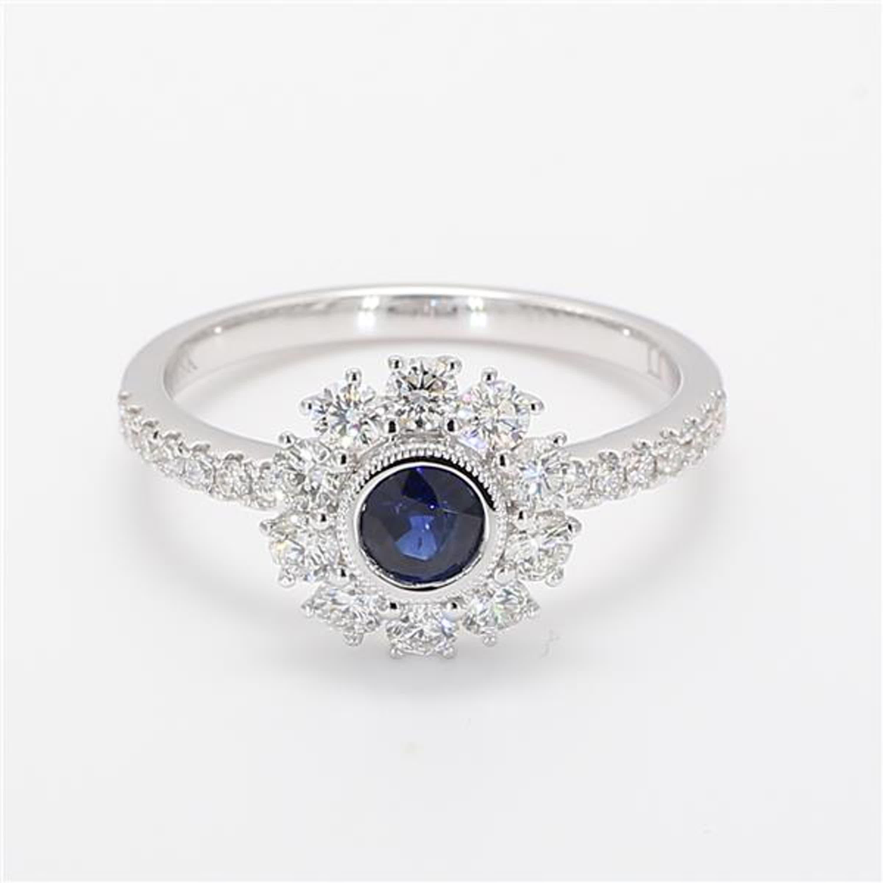 RareGemWorld's classic sapphire ring. Mounted in a beautiful 18K White Gold setting with a natural round cut blue sapphire. The sapphire is surrounded by natural round white diamond melee. This ring is guaranteed to impress and enhance your personal