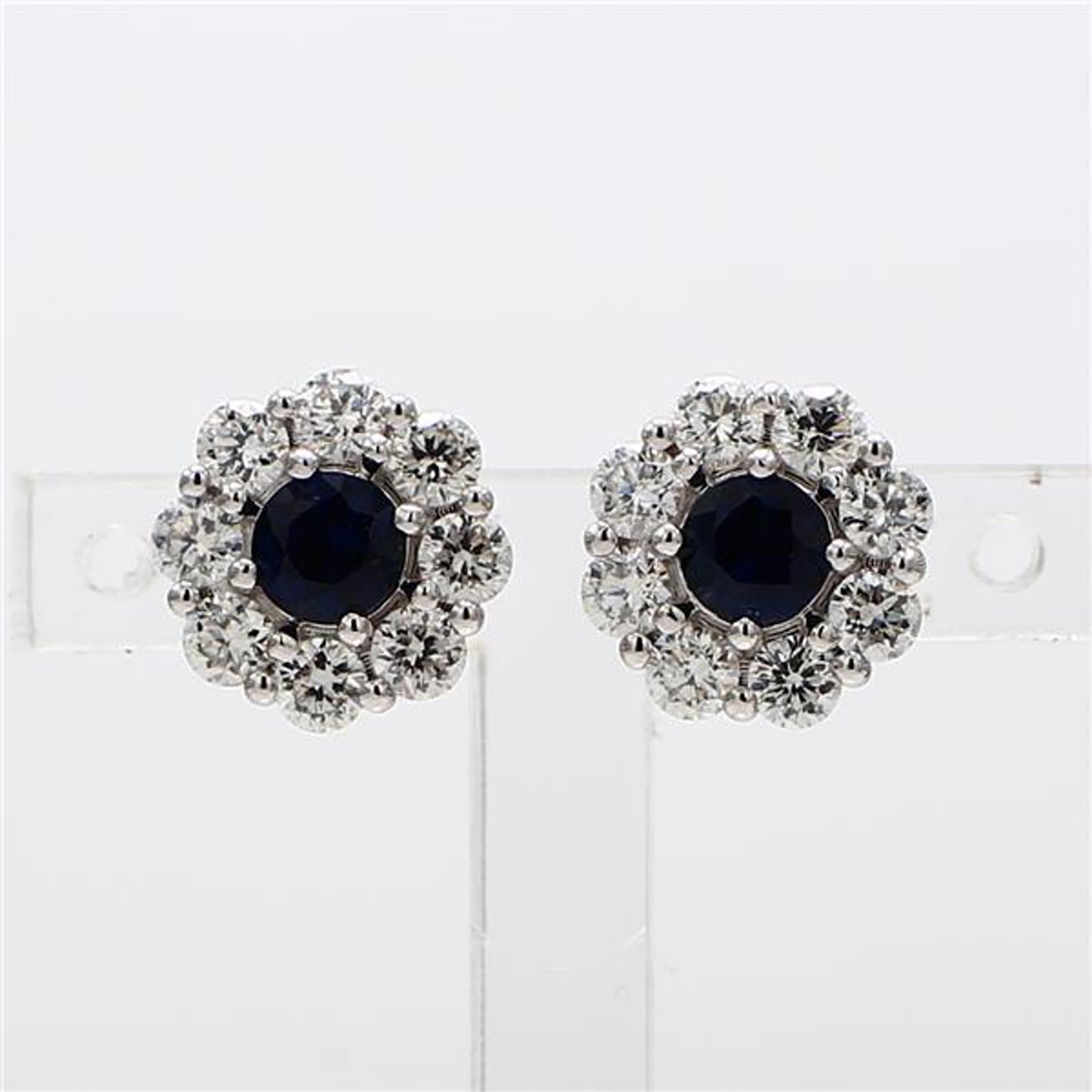 RareGemWorld's classic sapphire earrings. Mounted in a beautiful 14K White Gold setting with natural round cut blue sapphires. The sapphires are surrounded by natural round white diamond melee in a beautiful single halo. These earrings are