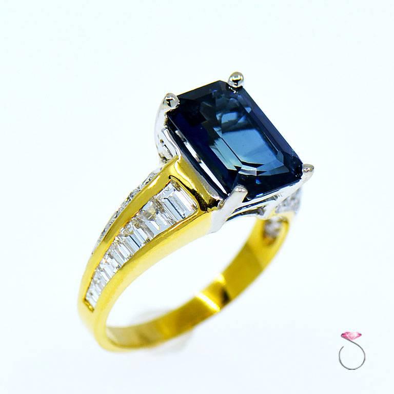 This gorgeous 4.95 ct. natural Nigerian Sapphire Gem is a real show stopper. Featuring a rich pleasant blue color that resembles the deep blue waters of the pacific. Set in an 18K yellow gold ring with accent baguette & round brilliant diamonds on