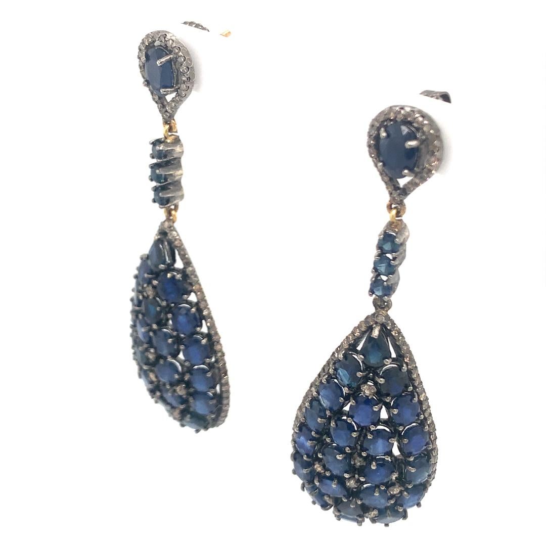 A gorgeous pair of earrings set in silver, with a 2.40-carat diamond and a natural 24.12-carat blue sapphire. 