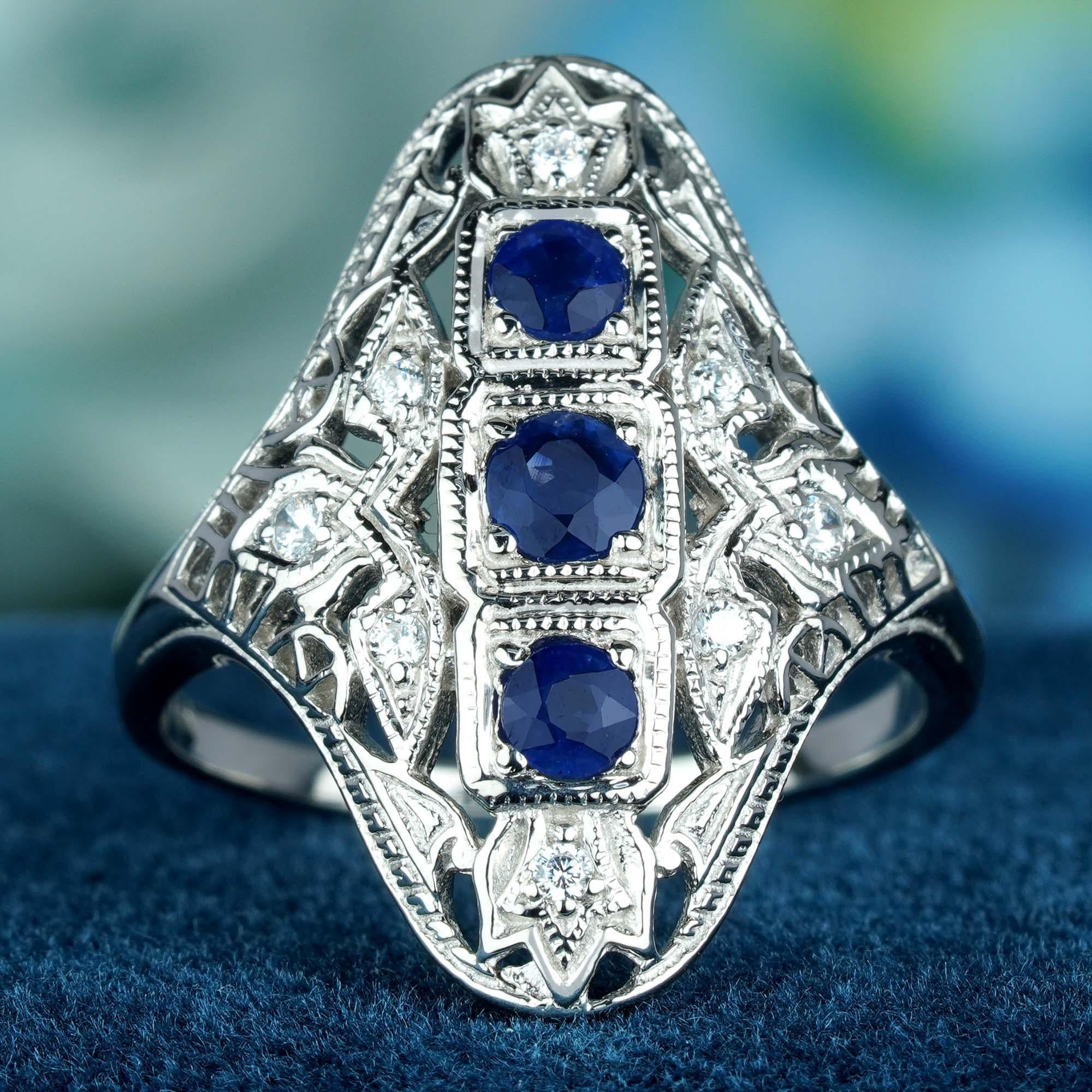 This Art Deco vintage-style ring features a central 3 cascading cluster of round blue sapphire set in a raised bezel, with delicate filigree work adorning the solid white gold band and shoulders adds a touch of femininity and romance to the ring.