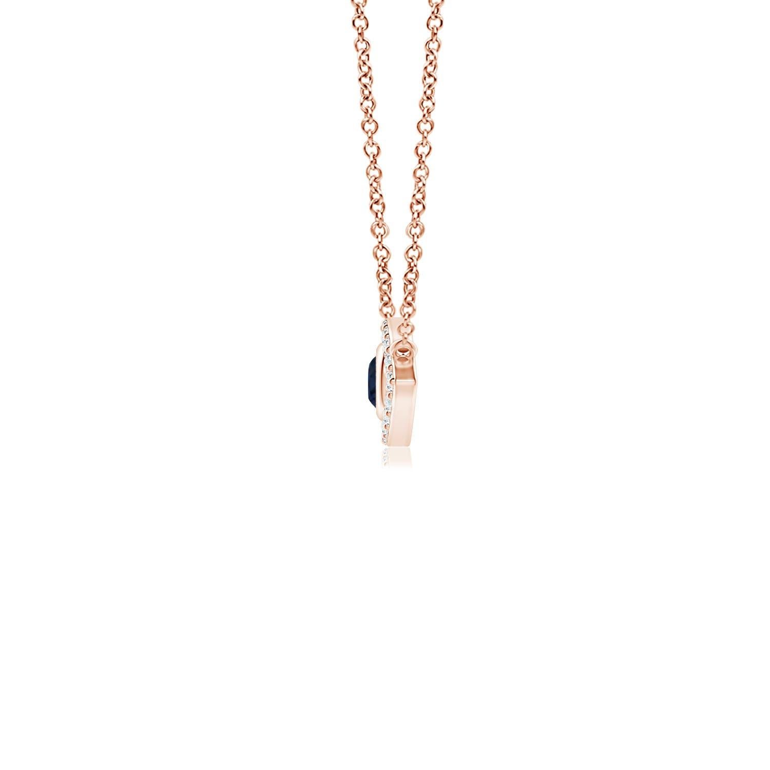 Hanging gracefully from a shiny metal bale is a diamond studded frame with a round sapphire bezel set at the center. The sparkling diamonds create a compelling contrast against the deep blue sapphire. Crafted in 18k rose gold, this sapphire evil eye