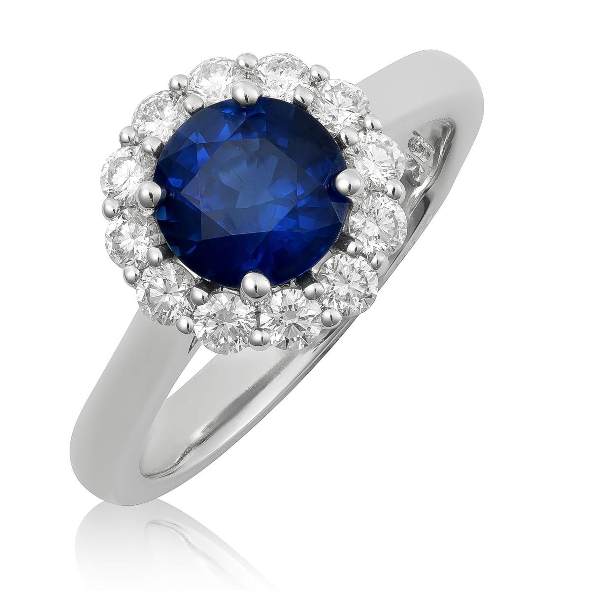 Entdecken Sie die zeitlose Eleganz dieses Rings aus 18 Karat Weißgold mit einem natürlichen blauen Saphir, der von funkelnden Diamanten akzentuiert wird. Der sattblaue Saphir im Rundschliff, gepaart mit Brillanten, ist ein elegantes Schmuckstück,
