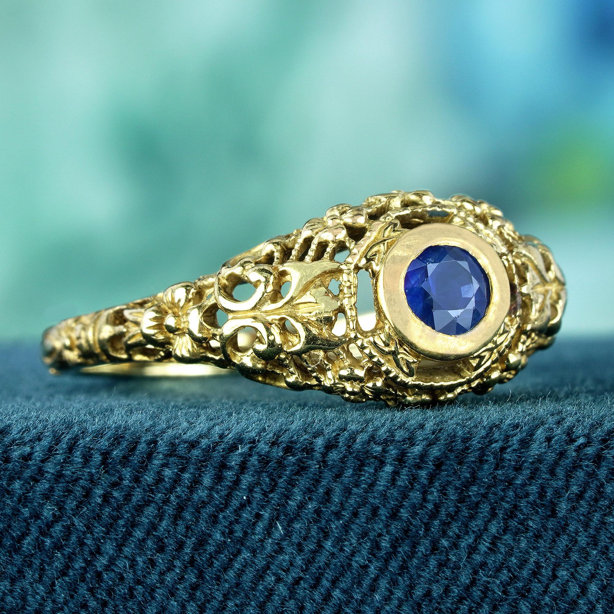 Fachmännisch aus filigranem Gelbgold gefertigt, umschließt dieses bezaubernde Vintage-Design den runden blauen Saphir in seinem Zentrum mit zeitloser Eleganz. Die filigranen durchbrochenen Verzierungen verleihen dem Ring einen Hauch von