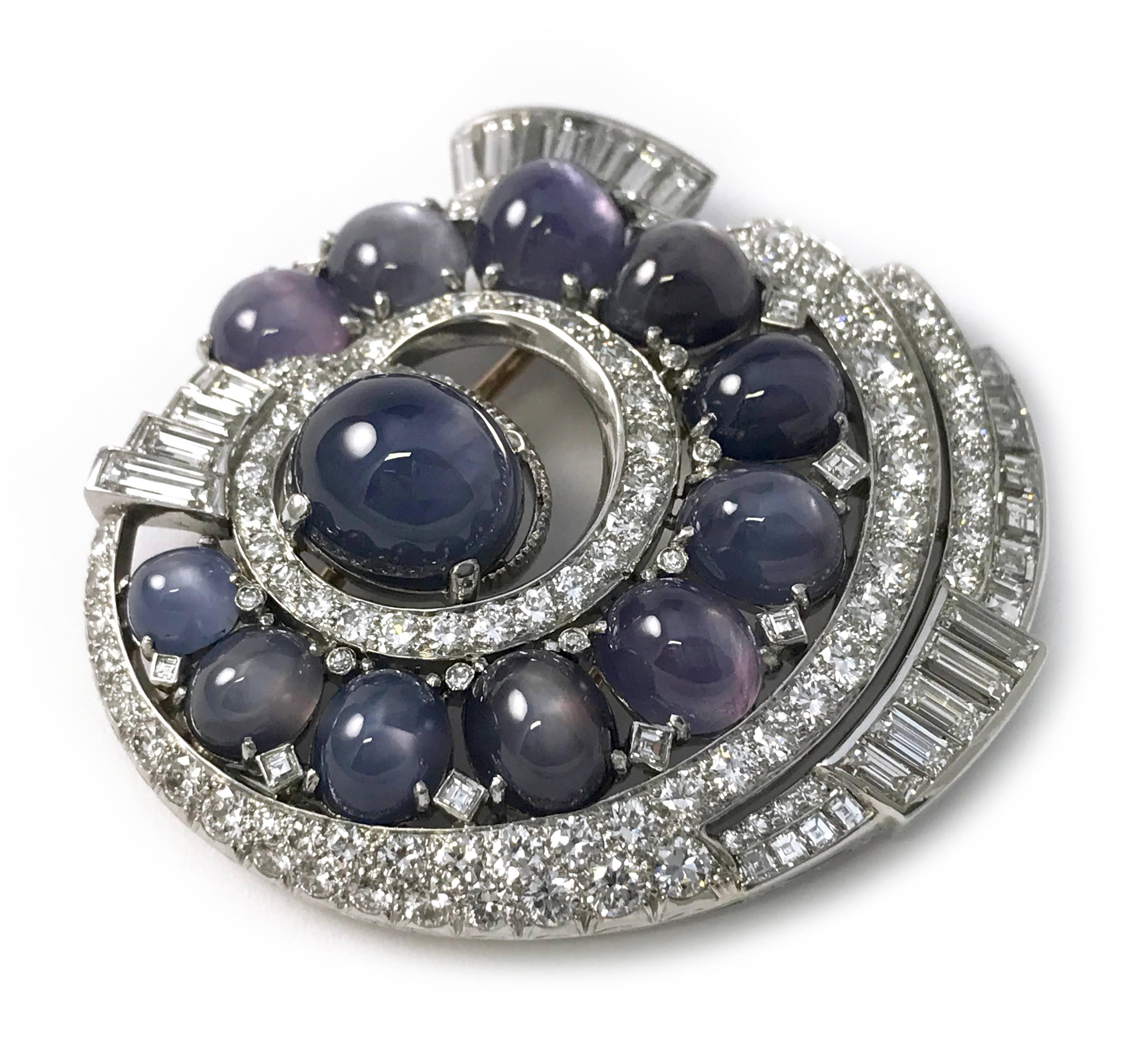 Natural blue star sapphire diamond brooch in an elaborate spinal floral design. Twelve prong set oval cabochon natural star sapphires (GIA vslgB 6/2), all stones have a complete six-star ray with medium intensity and good moment. Sixteen channel set