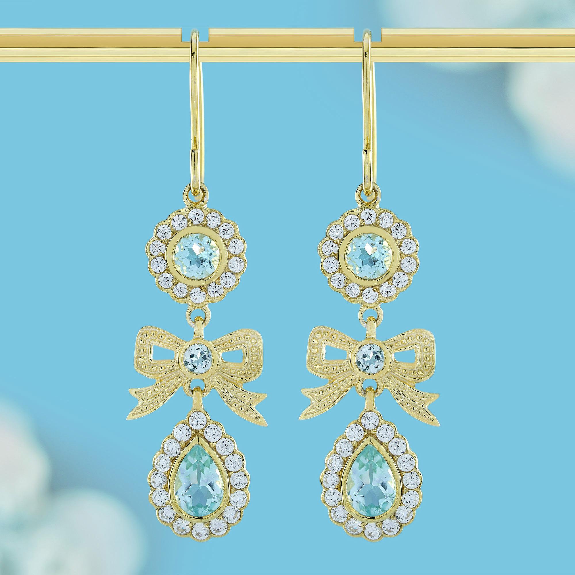 Step into timeless elegance with these captivating vintage-inspired earrings, boasting a dangle design with a lustrous gold finish, blending classic and contemporary elements seamlessly. The upper section showcases a round sky blue topaz surrounded