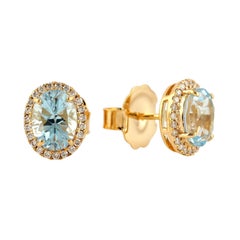 Boucles d'oreilles à clous avec topaze bleue naturelle et halo de diamants, en or jaune 18 carats