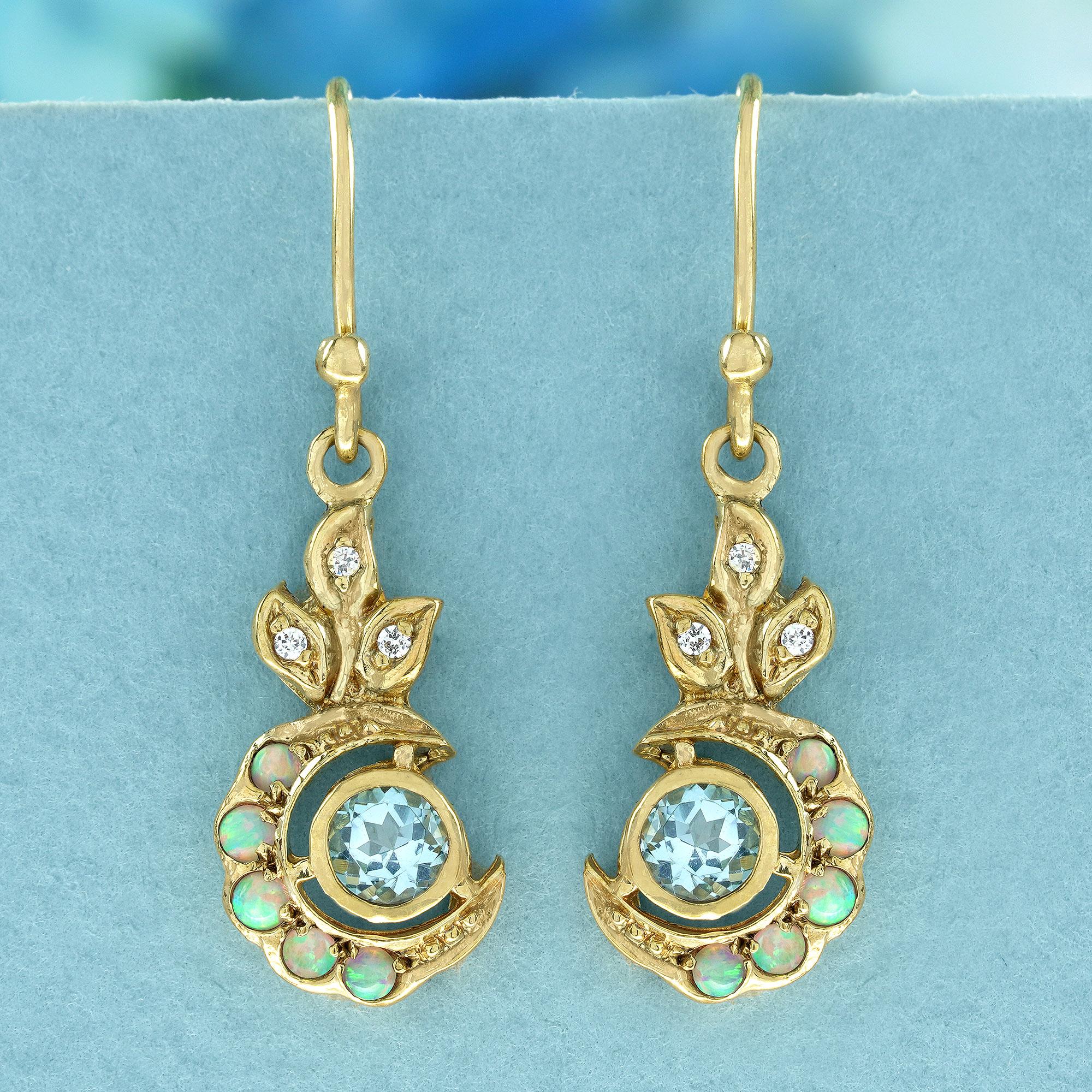 These enchanting vintage-inspired dangle earrings bloom with vibrant color. A round blue topaz gemstone take center stage, nestled in a crescent moon of warm yellow gold.
 Delicate white opals peek through the gold, adding a touch of shimmer and