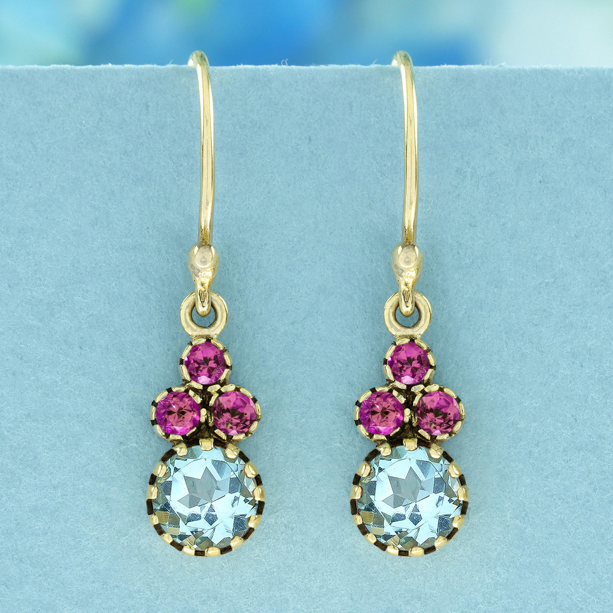 Schmücken Sie sich mit den atemberaubenden Tropfenohrringen im Vintage-Stil mit natürlichem Blautopas und rosa Turmalin aus 9 Karat Gelbgold! Diese exquisiten Ohrringe sind mit einem charmanten Cluster aus drei rosafarbenen Turmalinen versehen, die