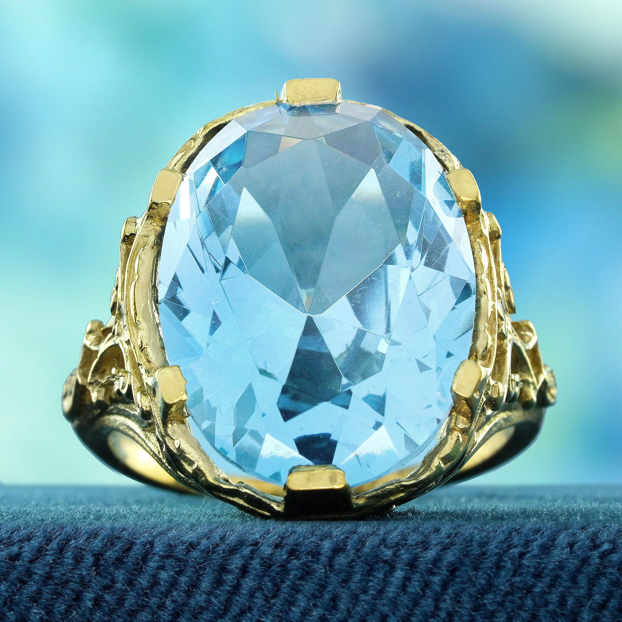 Ornez votre main d'une esthétique délicate et unique grâce à cette bague cocktail de style vintage. Avec ses motifs dorés complexes et tourbillonnants entourant une pierre centrale en topaze bleue, cette bague respire l'élégance classique avec un