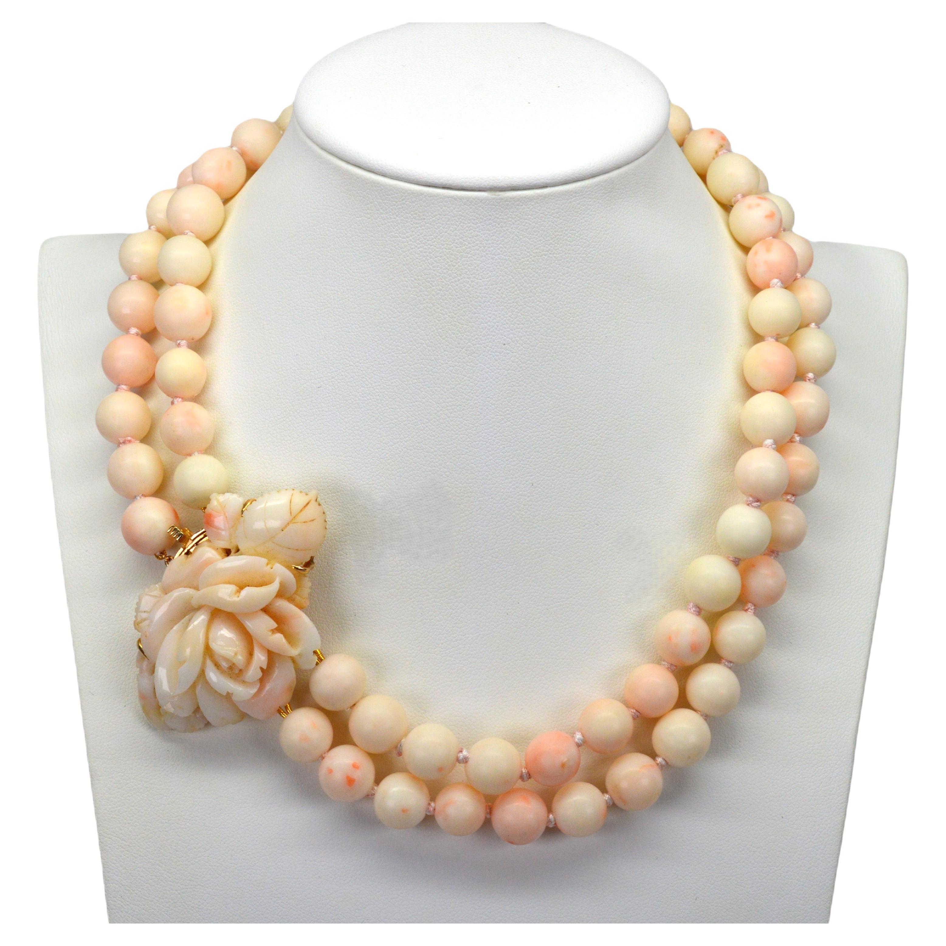 A stunning floral bloom that is meticulously hand carved in blush-toned natural coral presents mid-century vintage elegance on this unique estate beaded necklace. Seventy two hand knotted and freshly restrung 10mm variegated coral beads create the