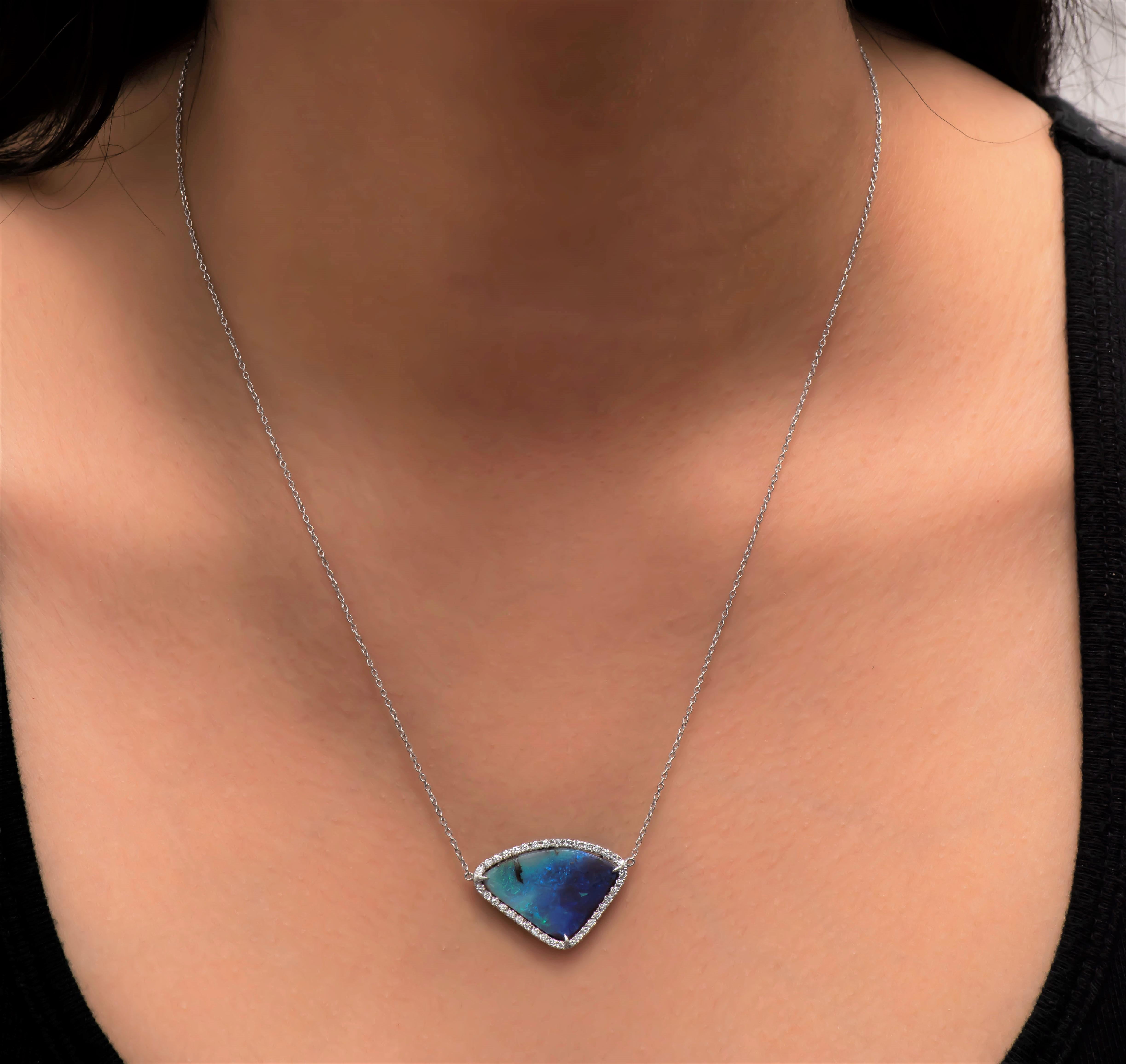 Natural boulder opal set in a halo of 0.36 carats total in fine round brilliant cut diamonds set in a 14K white gold pendant that is attached to a 18