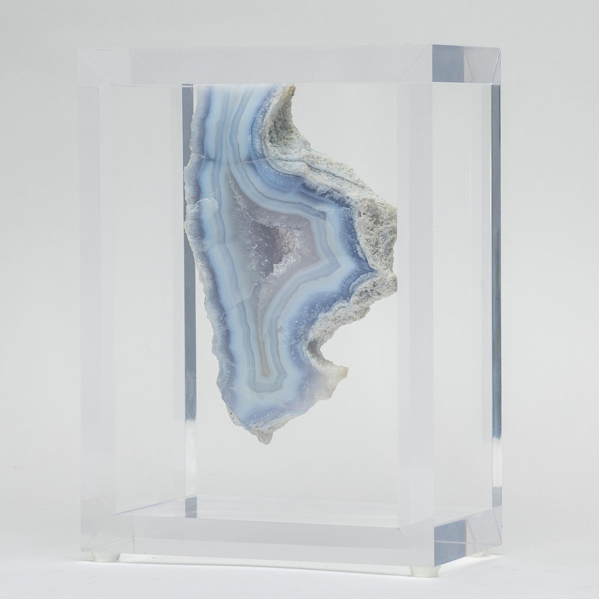 A unique specimen of free form blue agate from Brazil. With impressive reflective luster and natural growth lines.  Mounted in an original acrylic case design. 

