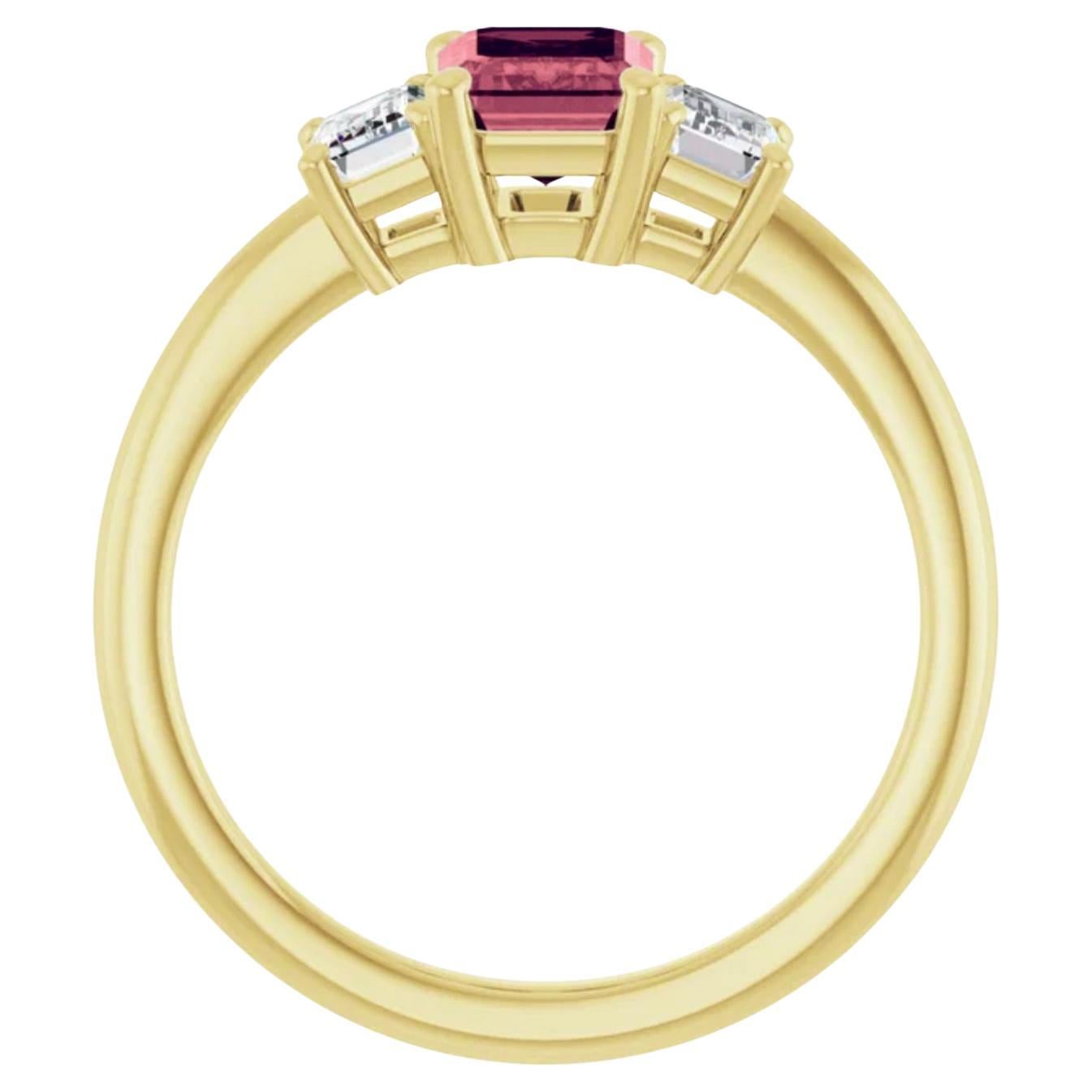 Rouge saphir unique à la lumière du jour /  Le saphir central de taille émeraude est serti de deux diamants latéraux de taille émeraude dans une monture à trois pierres en or jaune 14K. 
Saphir taille émeraude simple, poids total 1.95cts, 7.2mmx