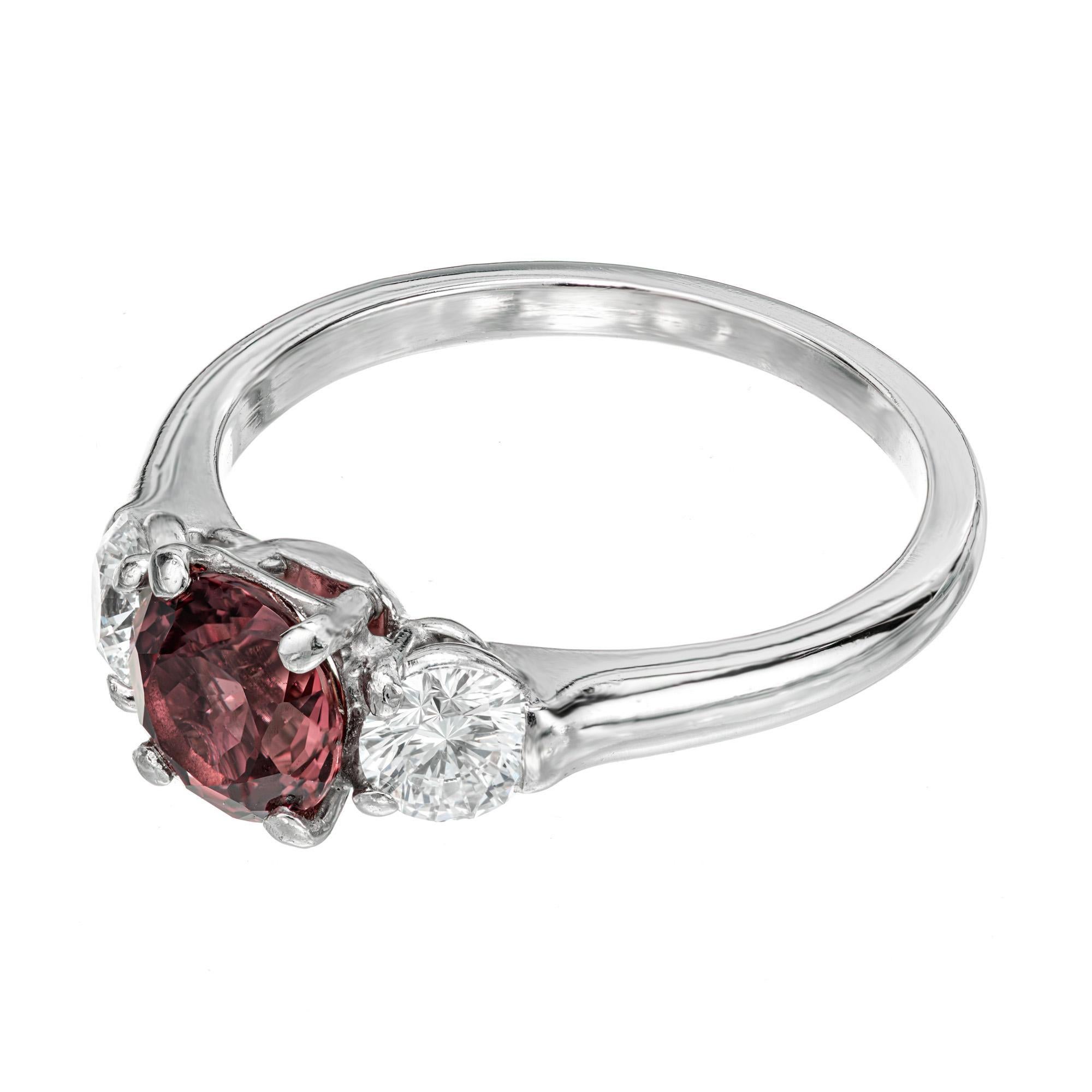 Sapphire and diamond engagement ring. GIA certified center brown and red center sapphire with 2 ideal cut side diamonds in a three-stone platinum setting. Color natural no heat, no enhancement Sapphire. Unique Raspberry color shifts to make pink is