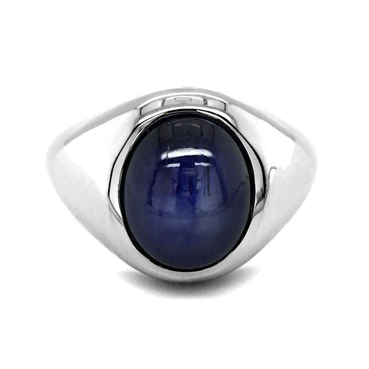 Discover distinguished men's ring features a stunning natural blue star sapphire, set in a classic 14K white gold band. The star sapphire is renowned for its unique star-like phenomenon, known as asterism, which appears on the surface when viewed