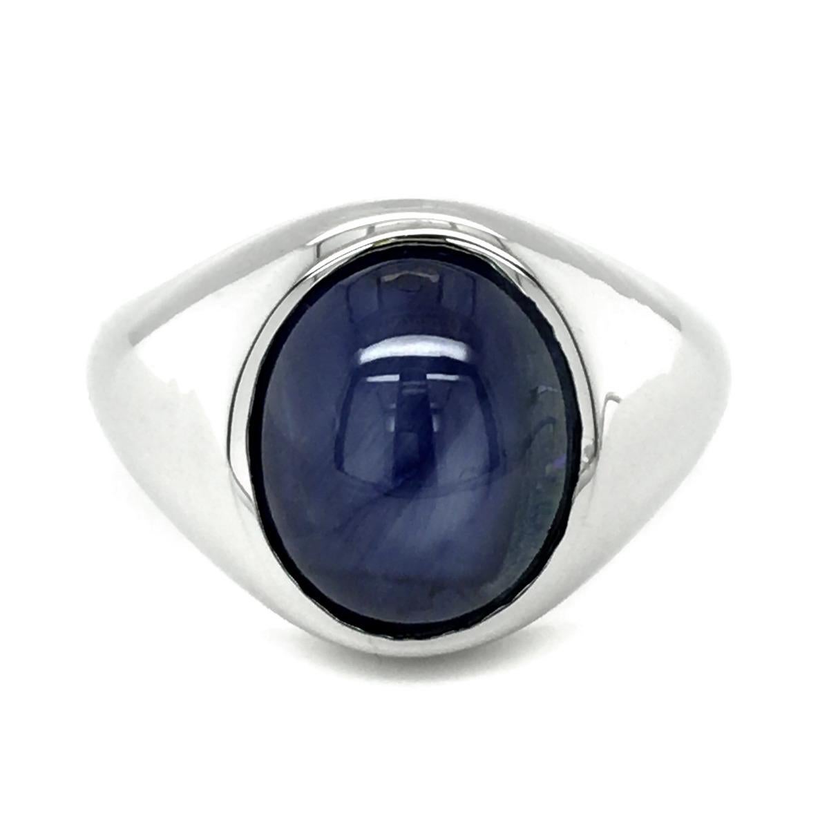 Discover distinguished men's ring features a stunning natural blue star sapphire, set in a classic 14K white gold band. The star sapphire is renowned for its unique star-like phenomenon, known as asterism, which appears on the surface when viewed