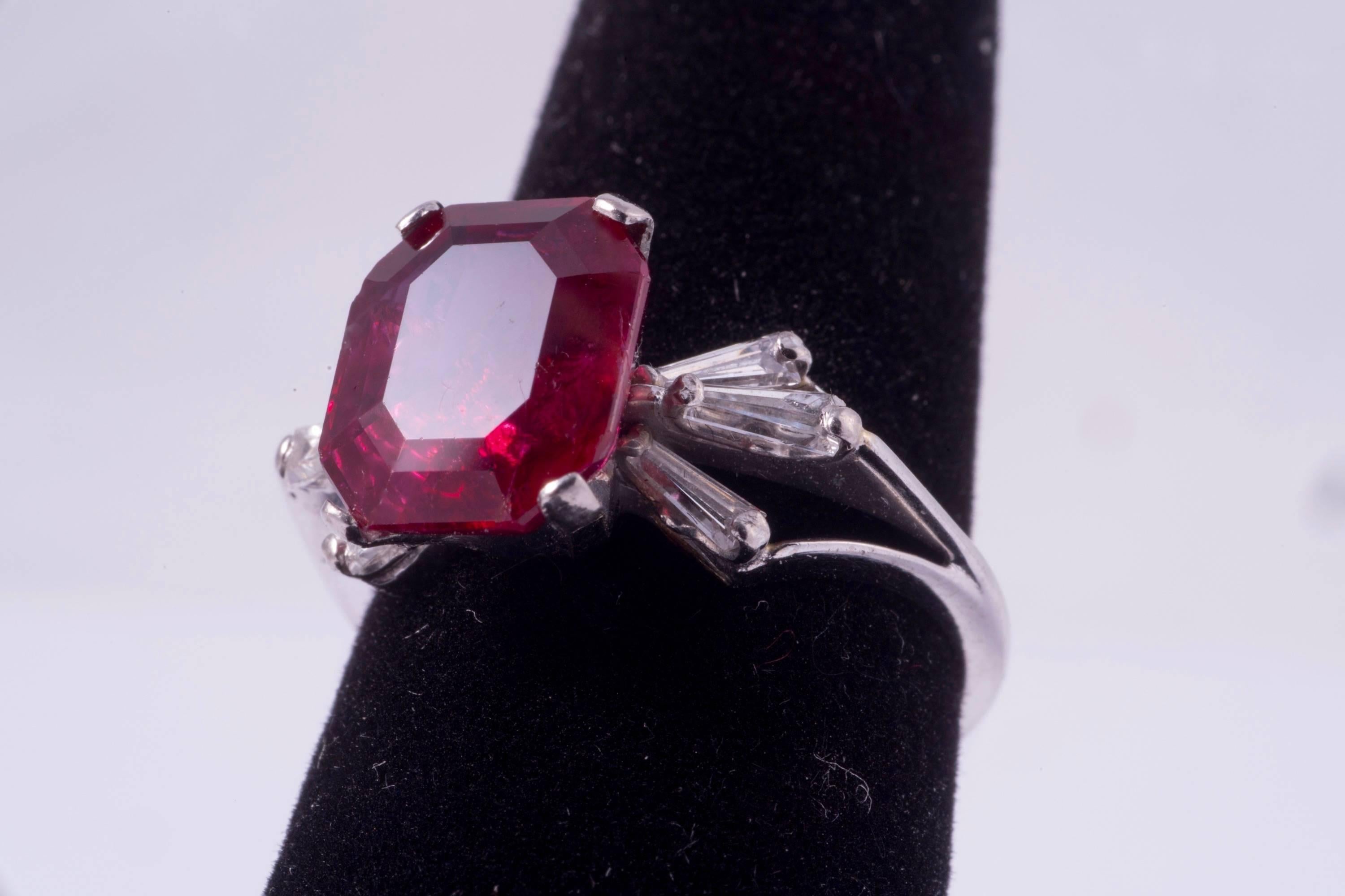 Beautiful natural, rectangular cut Burma ruby ring. The ruby weighs 4.21ct and measures 10.43 x 8.63 x 4.55mm.  The ruby was graded by the AGL, Report number CS 42640. The mounting is platinum with three taper baguettes on either side. Ring size