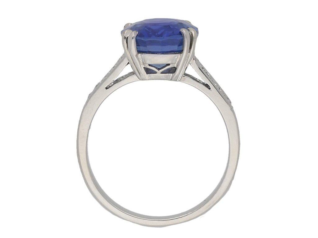 Burmese sapphire and diamond ring. Set with a cushion shape double brilliant natural unenhanced Burmese sapphire in an open back four claw setting with an approximate weight of 5.09 carats, flanked by eight round single cut diamonds in open back