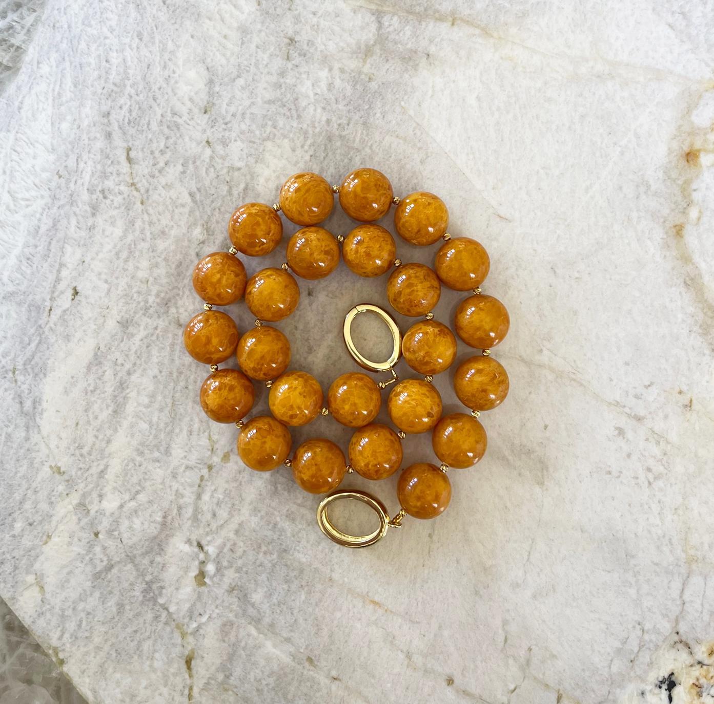 Beautiful natural butterscotch Baltic amber necklace comprised of 16mm round beads, tiny gold vermeil accent beads, and finished with an elegant interlocking  gold vermeil clasp. We love this clasp style. It is very easy to fasten on your own