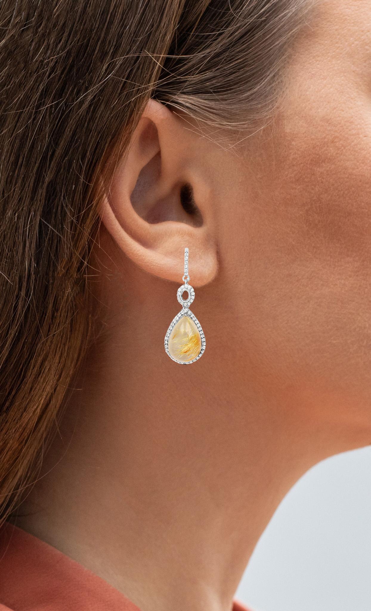 Il est accompagné d'une évaluation par la GIA GG/AJP. 
Quartz Rutile Doré = 9.55 Carats
Coupe : Cabochon
Topaze blanche = 0,50 carats
Métal : Argent Sterling
Plaqué Rhodium
Poteau avec dos de friction
Hauteur : 6,5 mm
Largeur : 13 mm
Longueur : 34,5