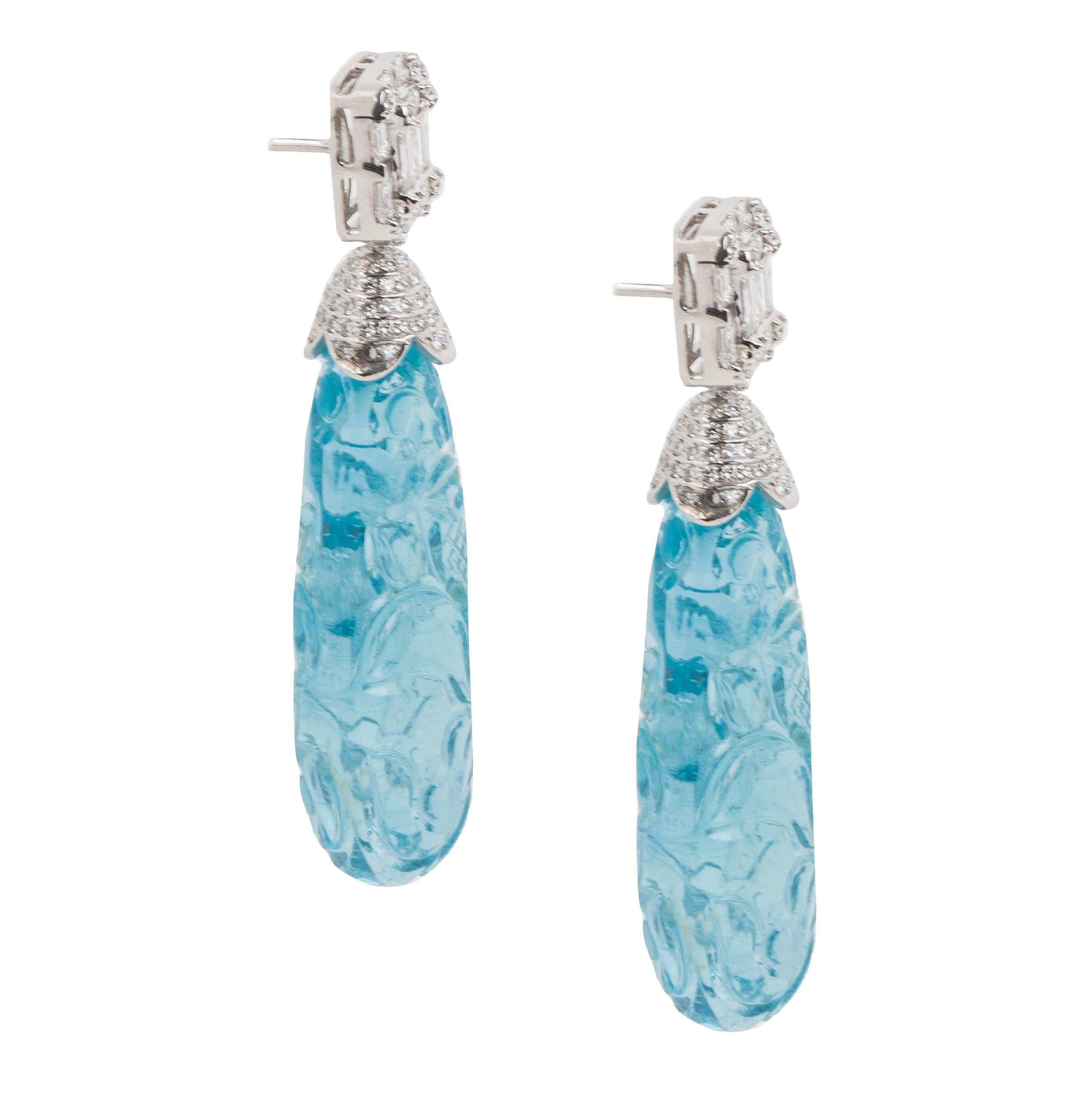 This pair of earrings features an aquamarine stone that has been carved with beautiful floral motifs. The color of the aquamarine is a deep sea blue in a perfectly even shape. The cap and top are studded with diamonds.

Aquamarine measurements -