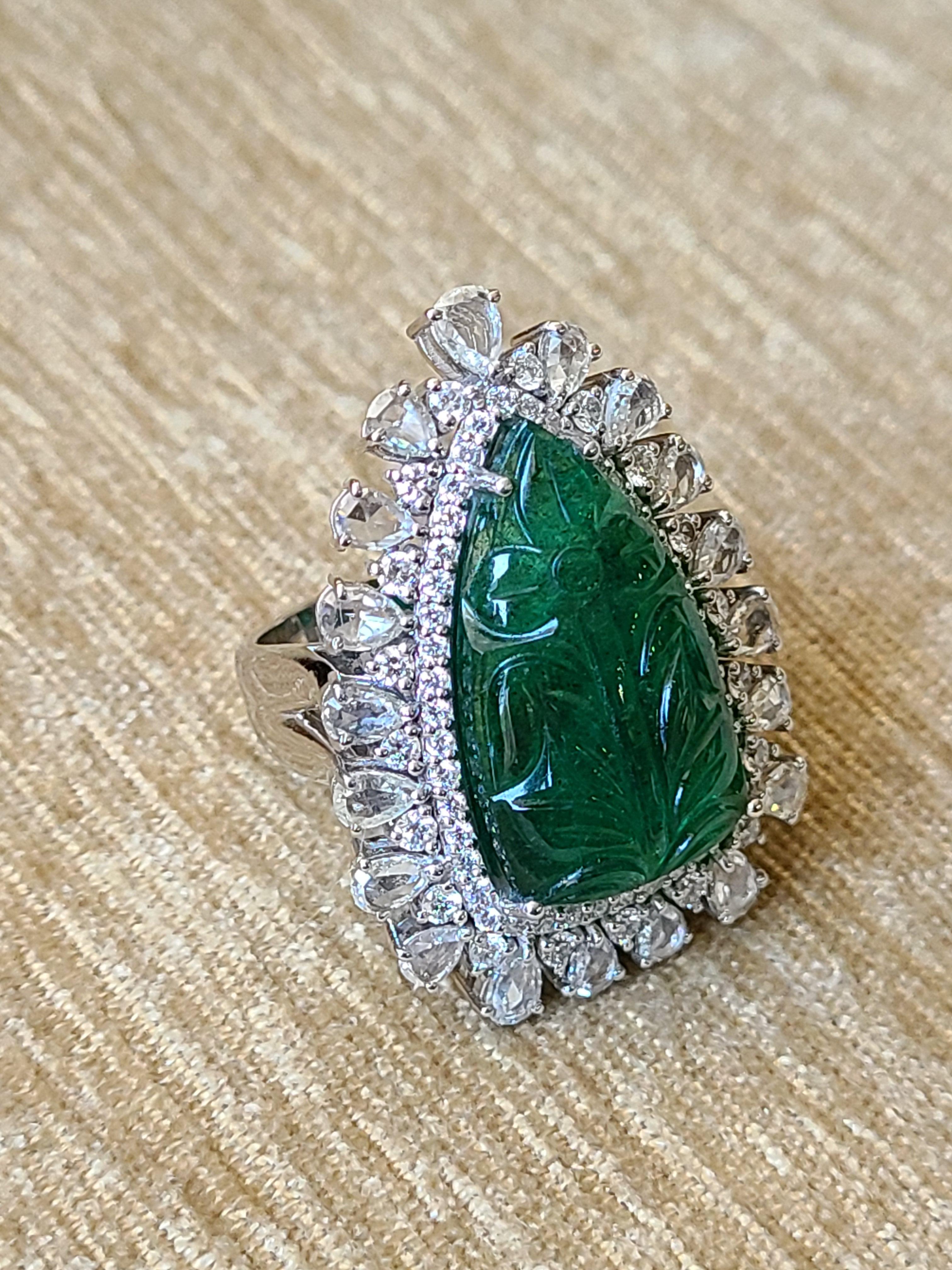 A beautiful and royal natural emerald and diamond rose cut ring set in 18k white gold. The natural carved emerald weight is 12.16 carats and diamond combined weight is 2.73 carats. The net gold weight is 12.04 grams and ring dimensions in cm 3.4 x