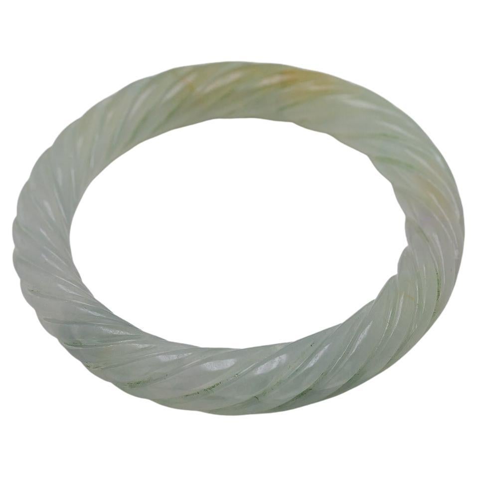 The carved, cable twist, natural, light greenish gray, translucent, jadeite jade, 74.90 X 10.41 mm, 236.73 carats, accompanied by a GIA Report, stating No indication of impregnation.
Note: some natural iron staining and semi coarse crystal