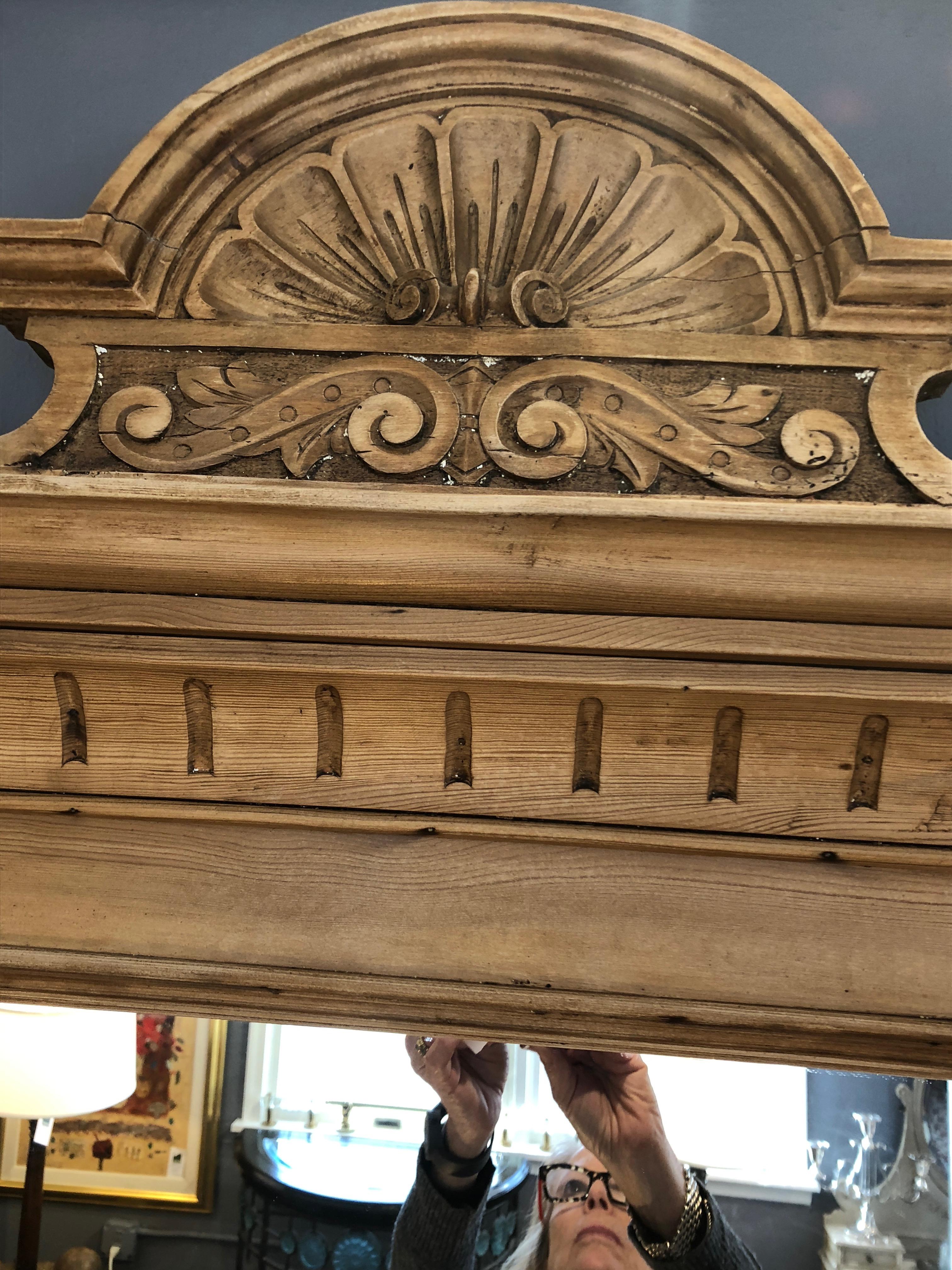 A beautiful natural carved wood Swedish mirror, probably originally the top part of a dresser commode, having shell shape at the top and two wooden protrusions at the bottom on each side.