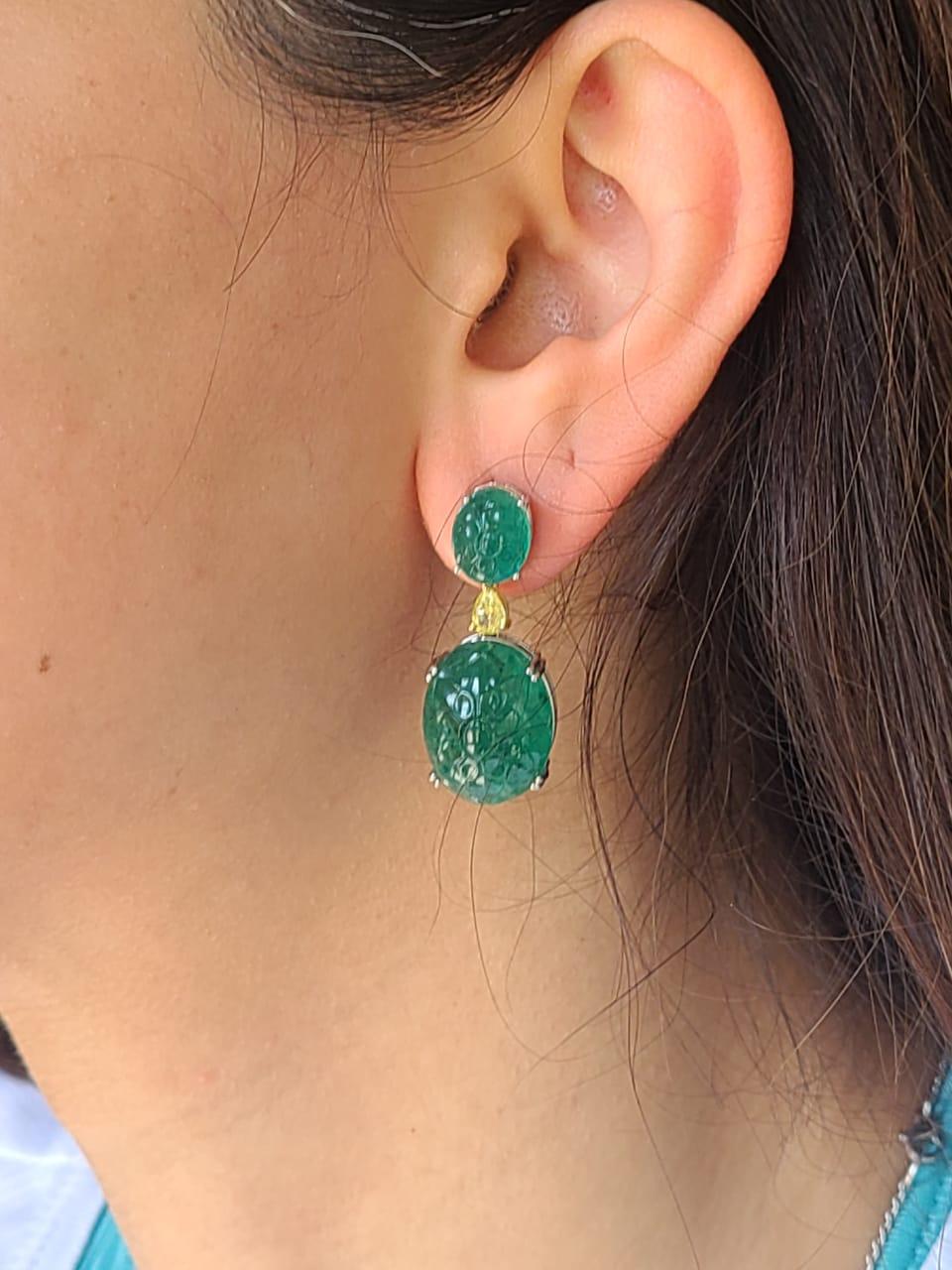 A very gorgeous and of a kind carved Emerald Drop Earrings set in 18K White Gold & Diamonds. The weight of the carved Emeralds is 34.28 carats. The Emeralds are completely natural, without any treatment & are of Zambian origin. The Emeralds are