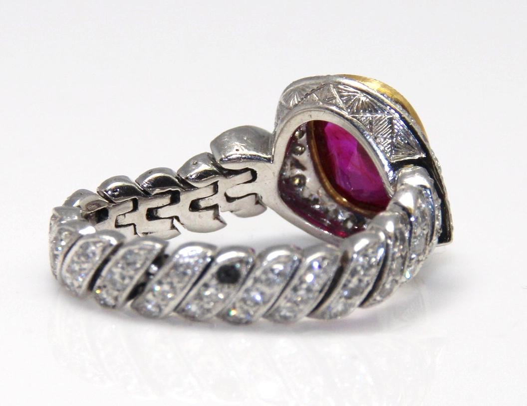 A Fine Natural Burma ruby and diamond ring weighing 2.76cts. The setting is unusual.  The ruby is set in a yellow gold collet mounted on to white gold chain shank set with diamonds all the way round. The Bezal is carved with intricate pyramids. 
The