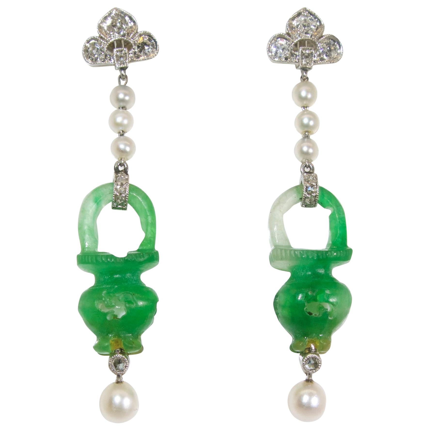 Earrings suspending natural jadeite jade (accompanied by a certificate) carved in an urn motif in round.  The delicate earrings are platinum with eight natural pearls and 22 small old cut and rose cut diamonds.  These delicate earrings, in fine