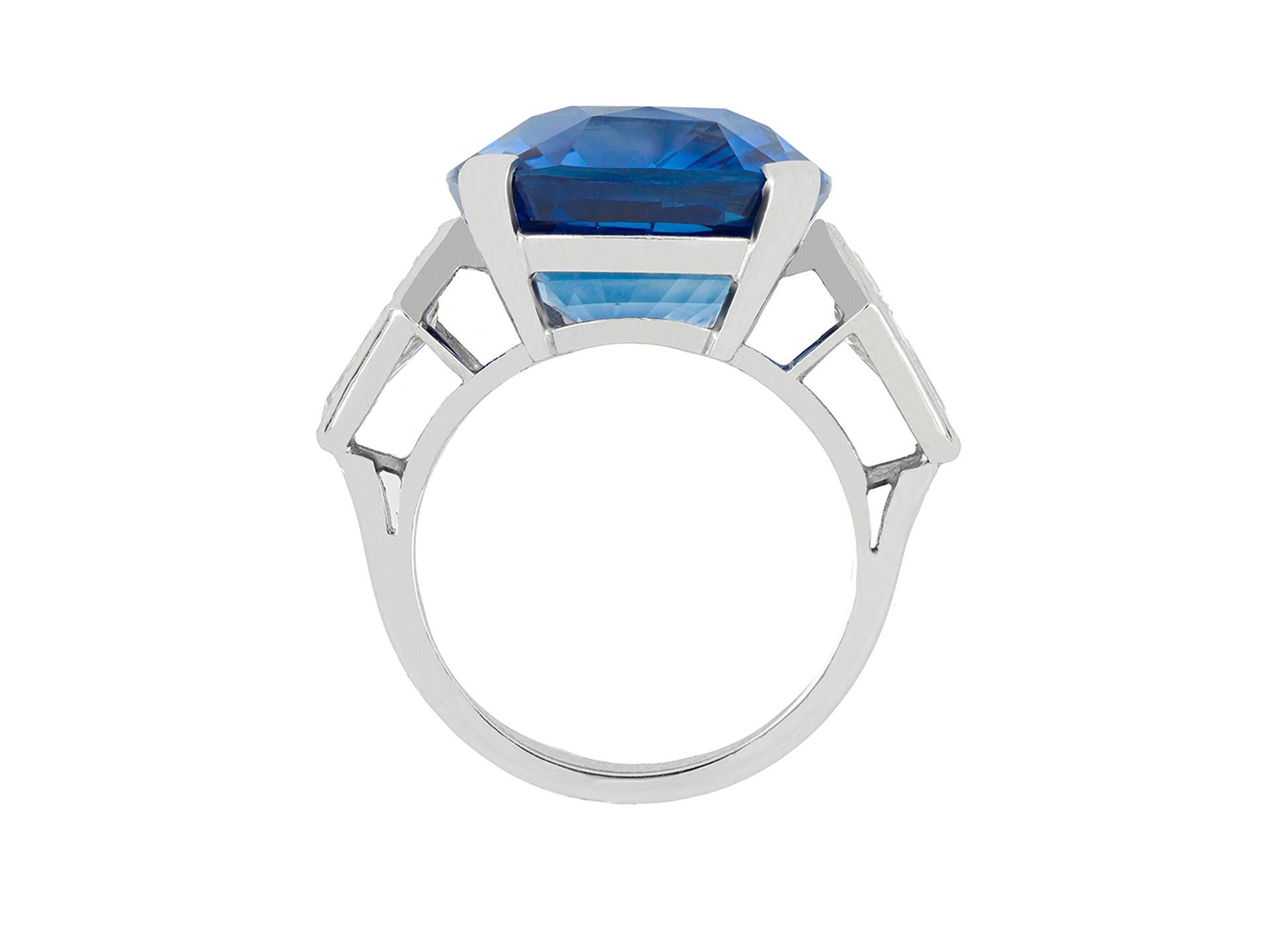 Natural Ceylon sapphire and diamond ring. An important piece, set to centre with a cushion shape old cut natural unenhanced Ceylon sapphire in an open back four claw setting with an approximate weight of 20.13 carats, flanked by two kite shape old