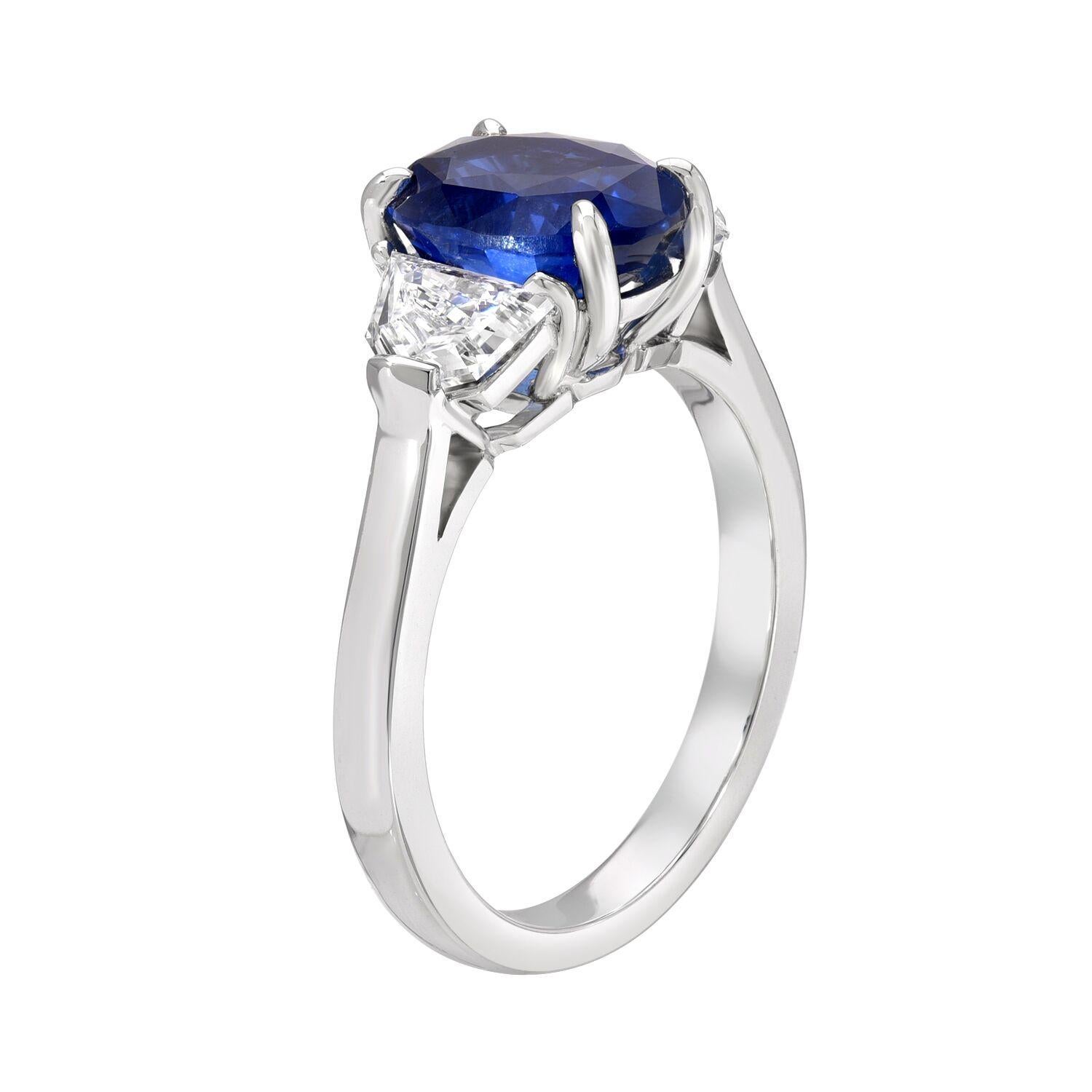 Sapphire engagement ring featuring a natural, unheated oval Ceylon Blue Sapphire, weighing a total of 3.42 carats, flanked by a pair of Epaulette shaped diamonds, totaling 0.88 carats, to create this fantastic platinum three-stone ring. 
Size 6.5.