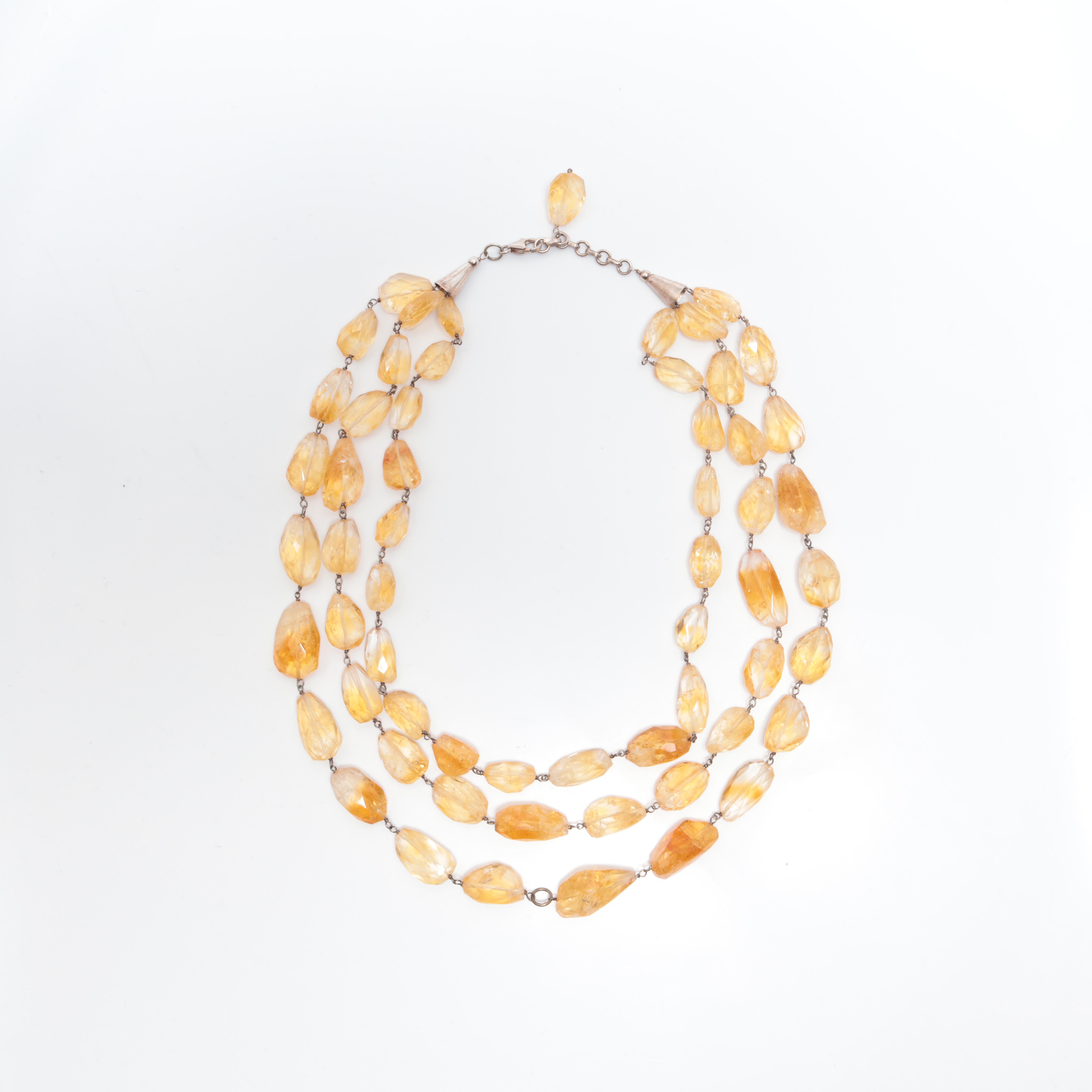 Brillantemente ejecutado e inconfundiblemente audaz, este collar artesanal de tres vueltas presenta una impresionante disposición de briolettes de citrino natural, cada una de ellas envuelta individualmente con alambre de plata de ley. Con una
