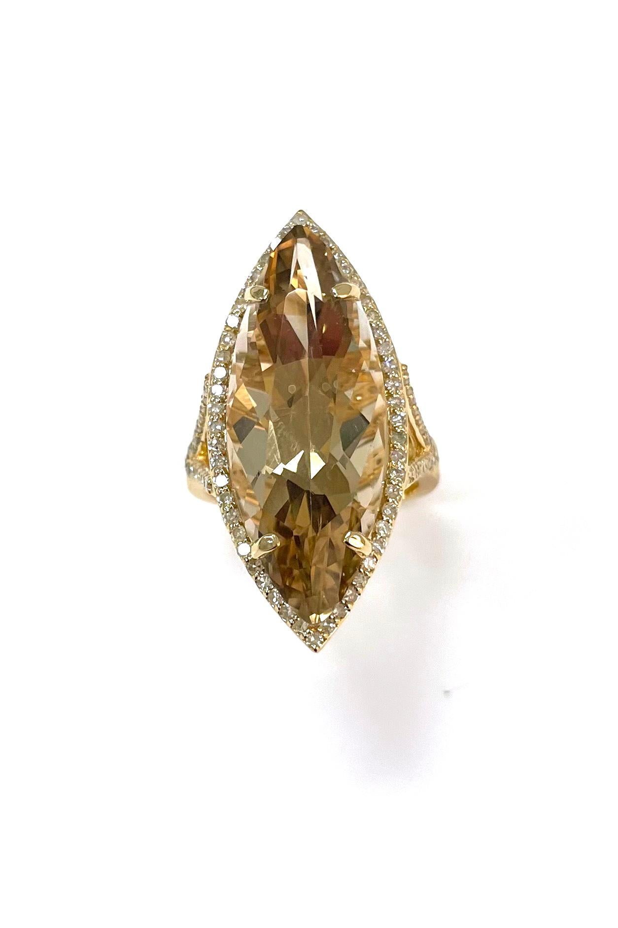 Description
Une rare citrine de couleur naturelle d'une qualité exceptionnelle, magistralement taillée en marquise à facettes de 16 carats, repose sur un anneau fendu en forme de panier de diamants surélevé et encadré d'un délicat halo de diamants -